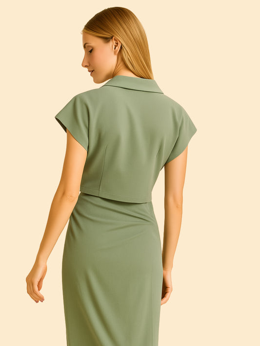 Moderna y refinada, esta blusa corta presenta un diseño cruzado que realza la figura con sutil elegancia. El cuello tipo polo y la botonadura frontal le dan un aire estructurado y contemporáneo, ideal para looks casuales elevados o conjuntos coordinados. Una prenda versátil para días cálidos con estilo impecable.