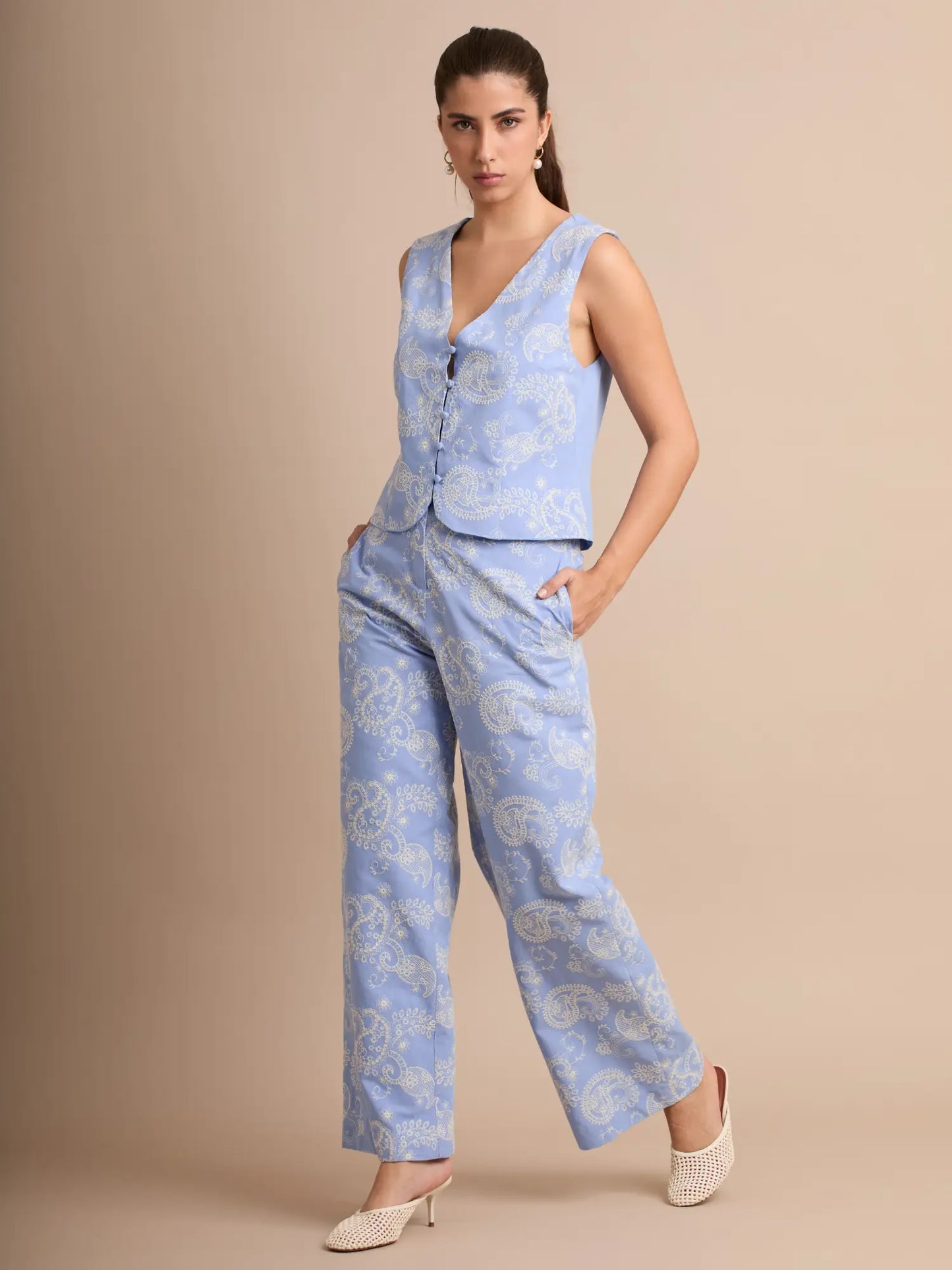 El set estilo boho presenta un llamativo estampado paisley sobre fondo azul. El chaleco con botones y el pantalón fluido crean un look relajado y moderno, ideal para días cálidos y salidas informales.