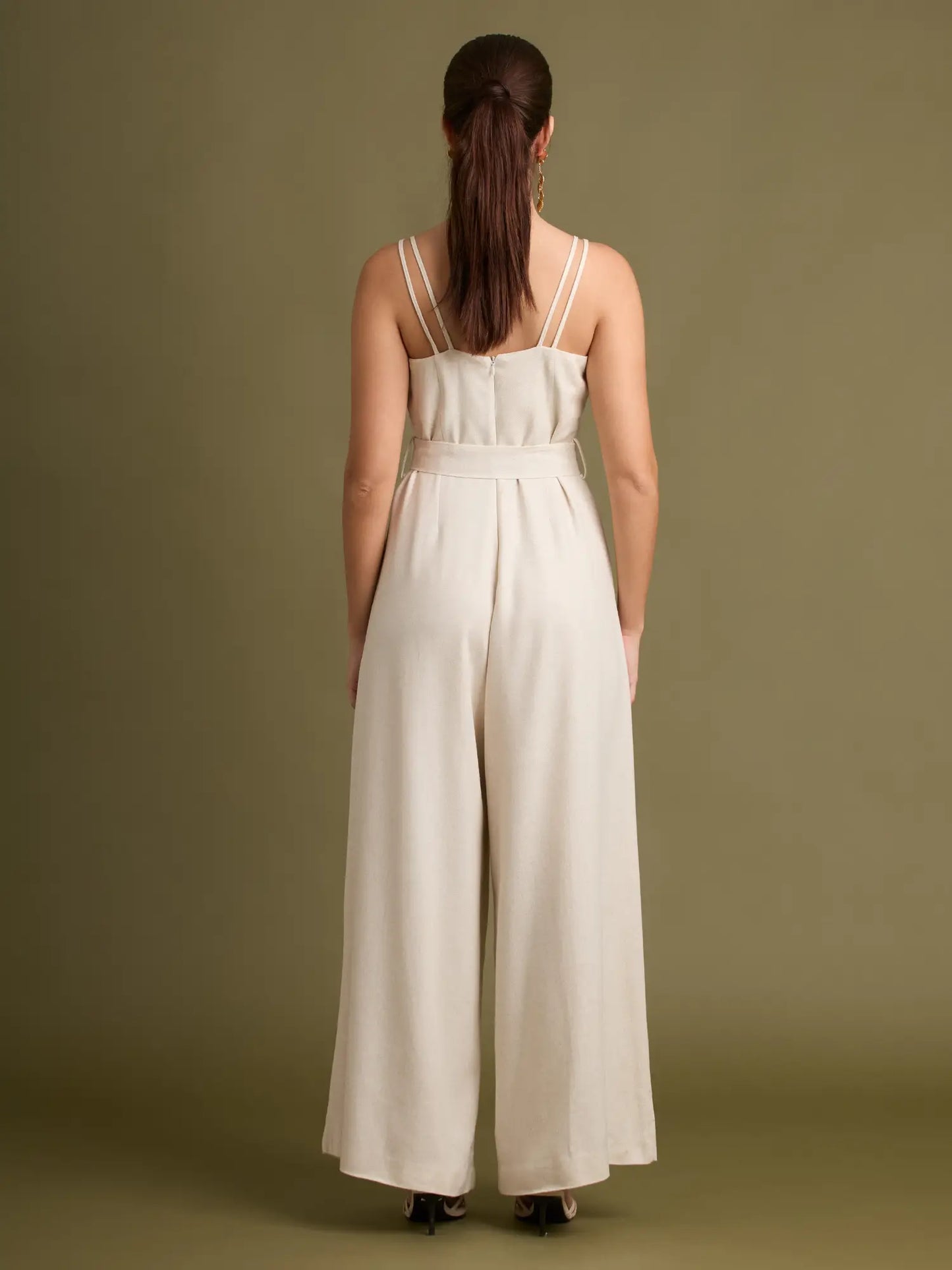 El enterizo neutral tiene una pierna amplia que aporta movimiento y un cinturón con hebilla que añade un toque chic. Perfecto para quienes buscan un look pulido sin esfuerzo.