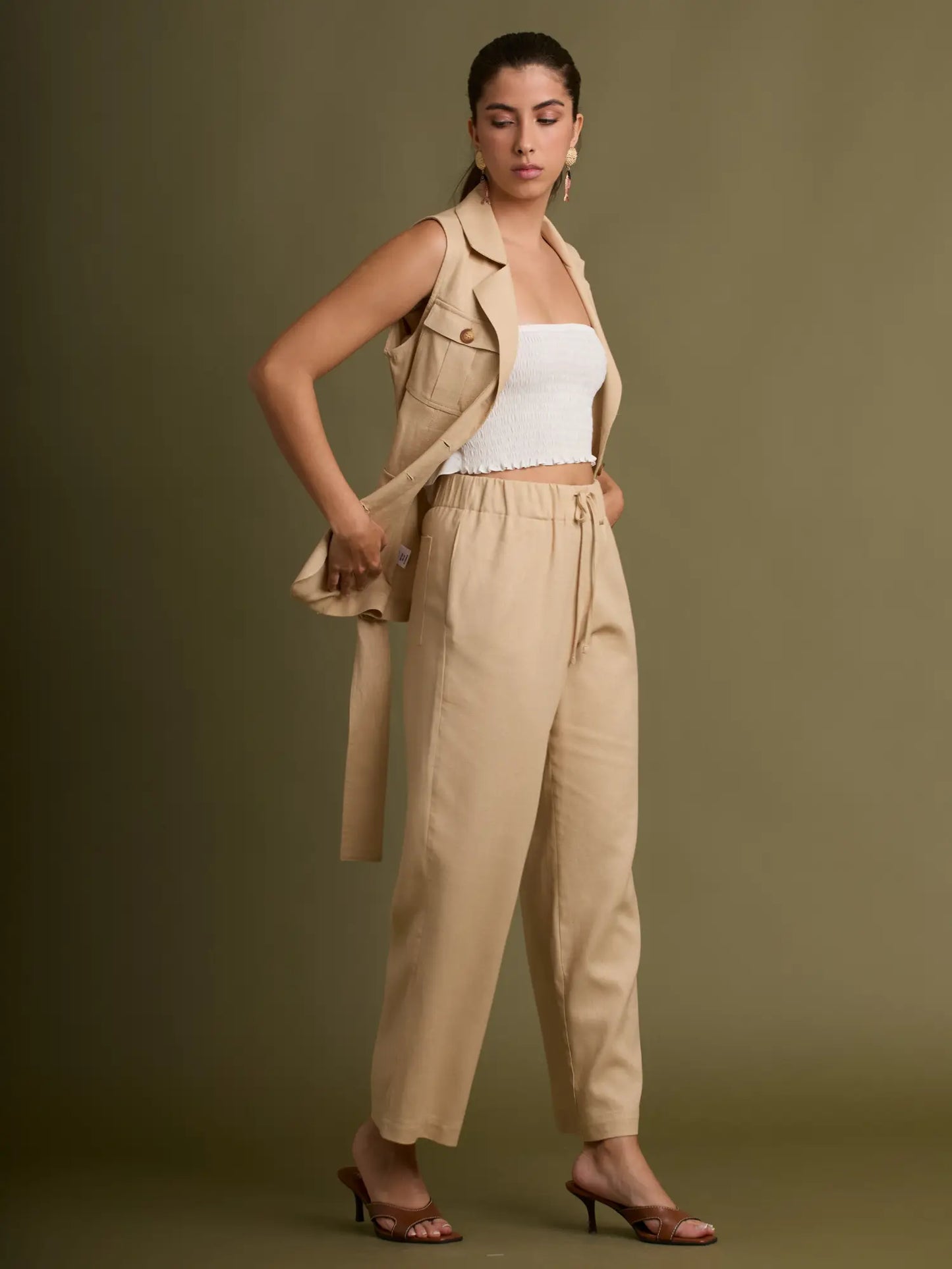 Este pantalón beige destaca por su corte recto y elegante, confeccionado en una tela ligera que brinda caída natural. Su diseño limpio lo convierte en una pieza versátil para looks formales o casuales.