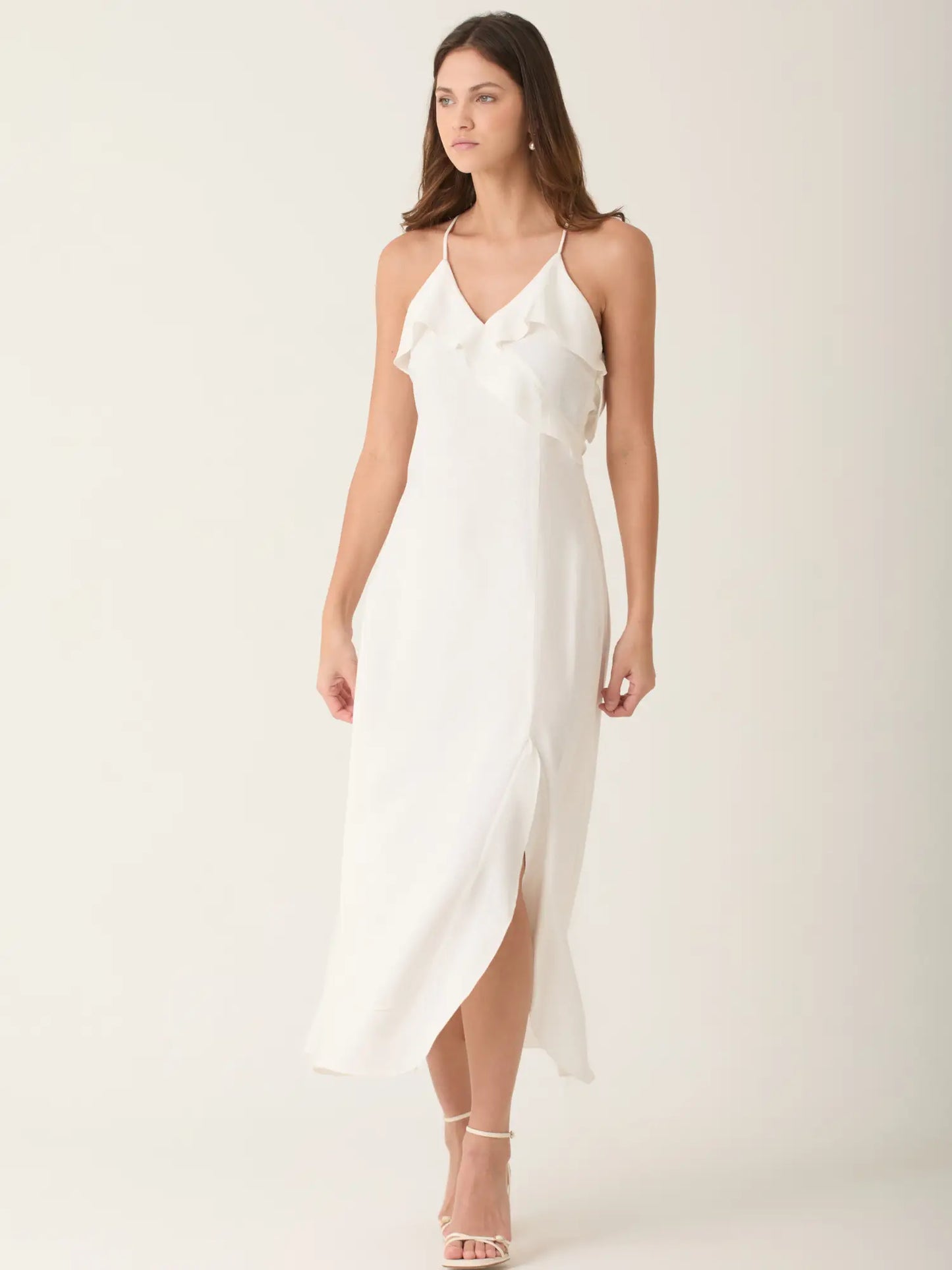 Vestido blanco largo con tirantes finos y escote en V que realza la silueta de forma delicada. El vestido alain blanco destaca por su caida fluida y abertura lateral, ideal para eventos, cenas o looks sofisticados de verano.