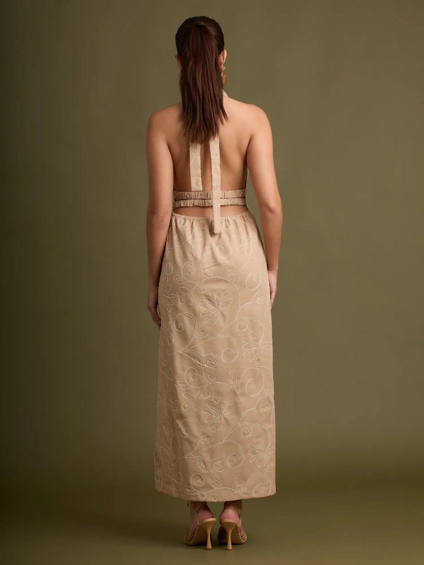 El equilibrio perfecto entre estilo y delicadeza: un vestido halter con bordado floral integral, caída fluida y corte lateral que estiliza la silueta con naturalidad.