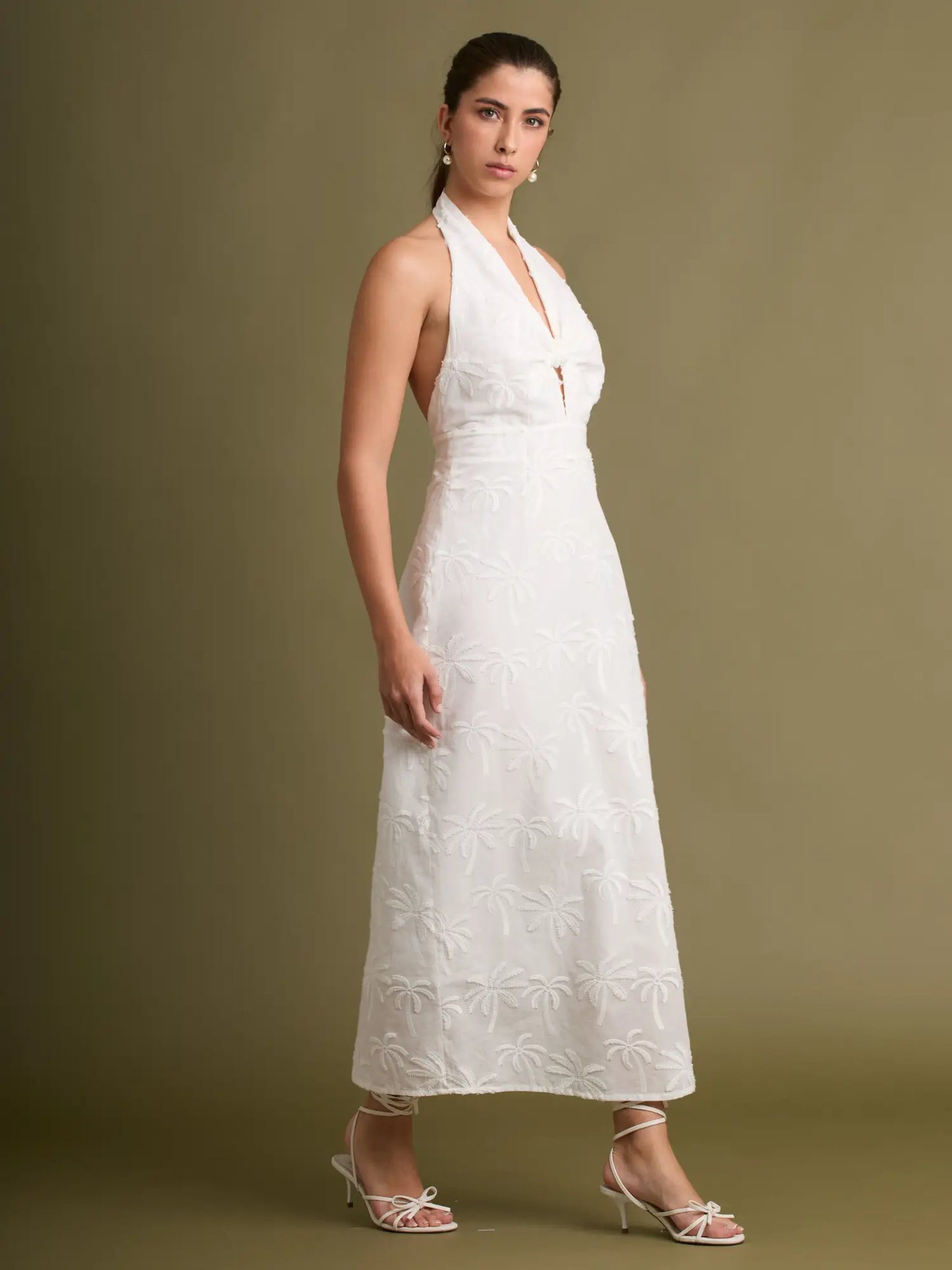 La combinación perfecta entre romanticismo y frescura: vestido halter blanco con nudo decorativo, acabado bordado y un corte midi que favorece cualquier figura.