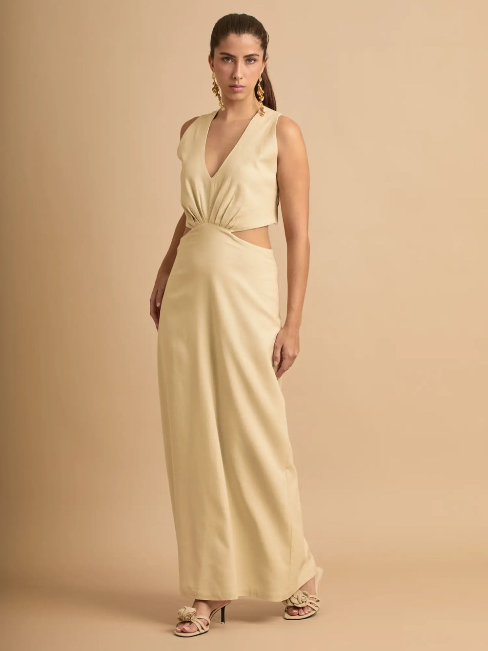 Este vestido midi beige destaca por su nudo frontal que define la figura y su caída fluida que aporta movimiento. Una pieza perfecta para lucir femenina y chic en cualquier ocasión.
