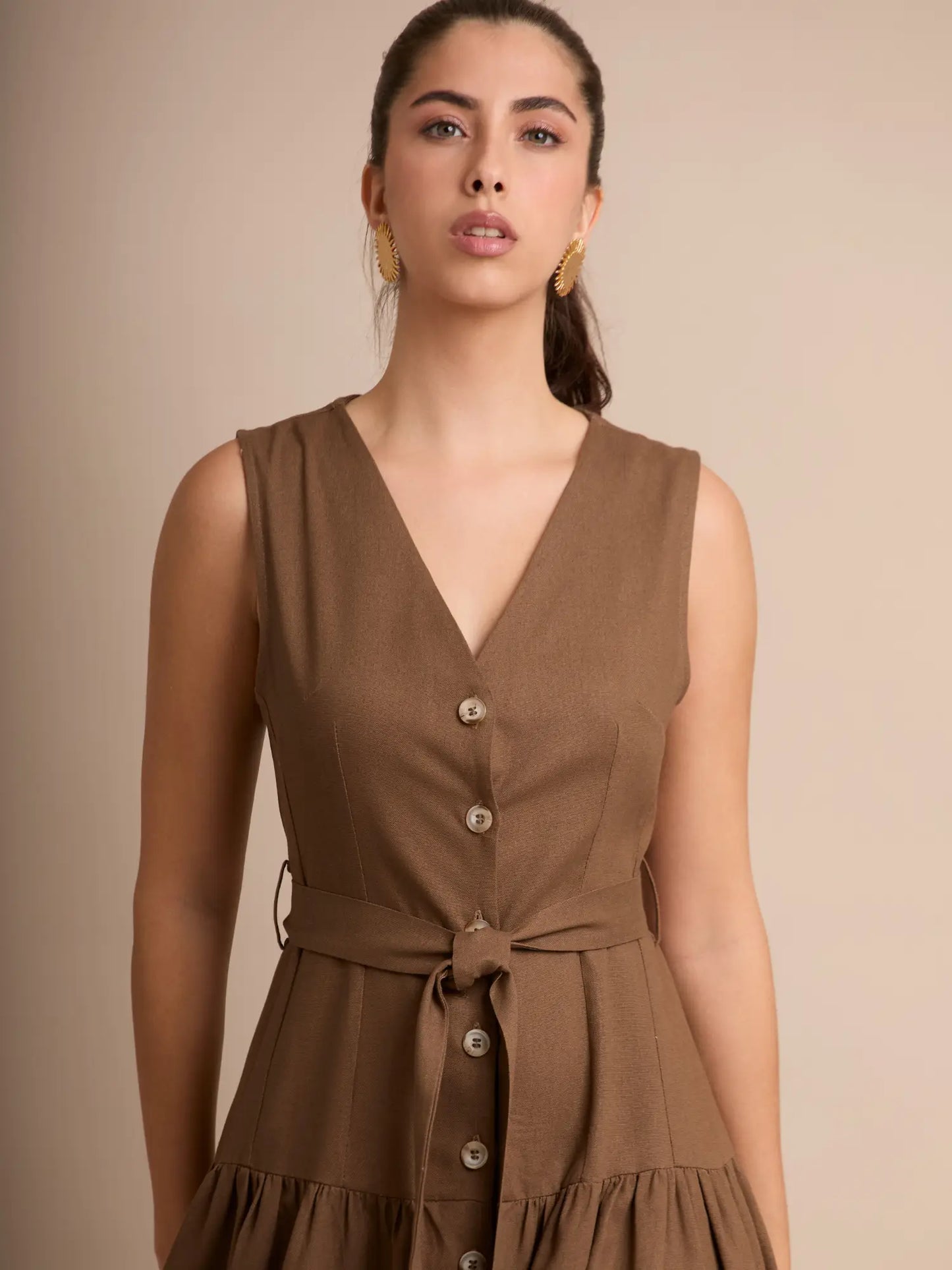 Un diseño que realza la figura con su corte ceñido en la parte superior y falda amplia. El detalle de los botones y el tono cálido lo convierten en una pieza versátil para cualquier ocasión.