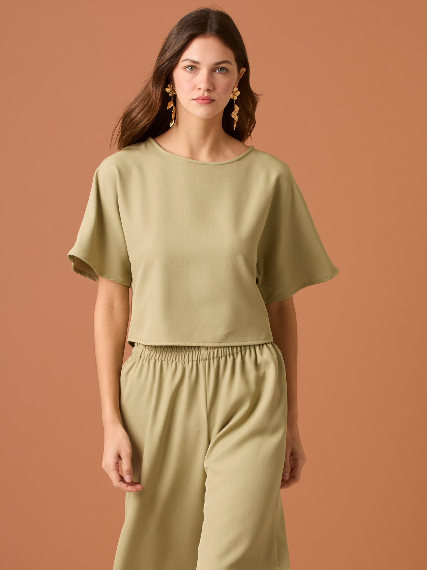 Sencilla y sofisticada, esta blusa de corte recto y fit suelto ofrece comodidad con un acabado limpio. Su diseño de manga corta y cuello cerrado la convierte en una prenda versátil, ideal para looks casuales o combinaciones minimalistas con un aire refinado. Perfecta para el día a día con estilo relajado y moderno.