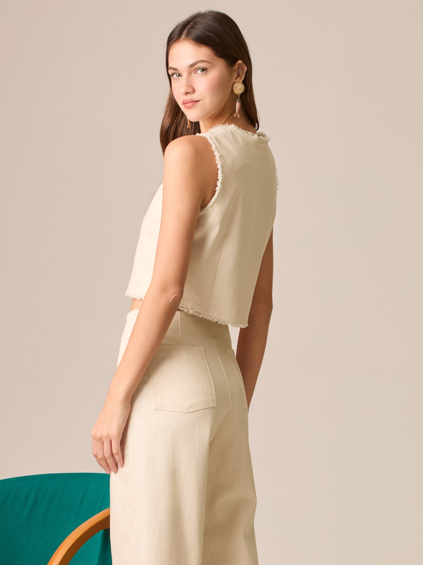 Blusa cropped sin mangas, escote redondo y botonadura frontal; bordes deshilachados y silueta entallada que realza la cintura—ideal para coordinar con tiro alto.
Detalles:
Color: Sand
Material: 98% Algodón 2% Elastomero
Cuidado: Lavar a mano con jabón suave, por separado.No dejar en remojo. Planchar a temperatura alta.