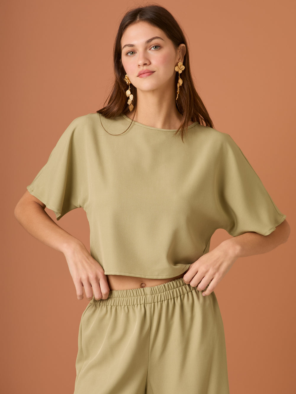 Sencilla y sofisticada, esta blusa de corte recto y fit suelto ofrece comodidad con un acabado limpio. Su diseño de manga corta y cuello cerrado la convierte en una prenda versátil, ideal para looks casuales o combinaciones minimalistas con un aire refinado. Perfecta para el día a día con estilo relajado y moderno.