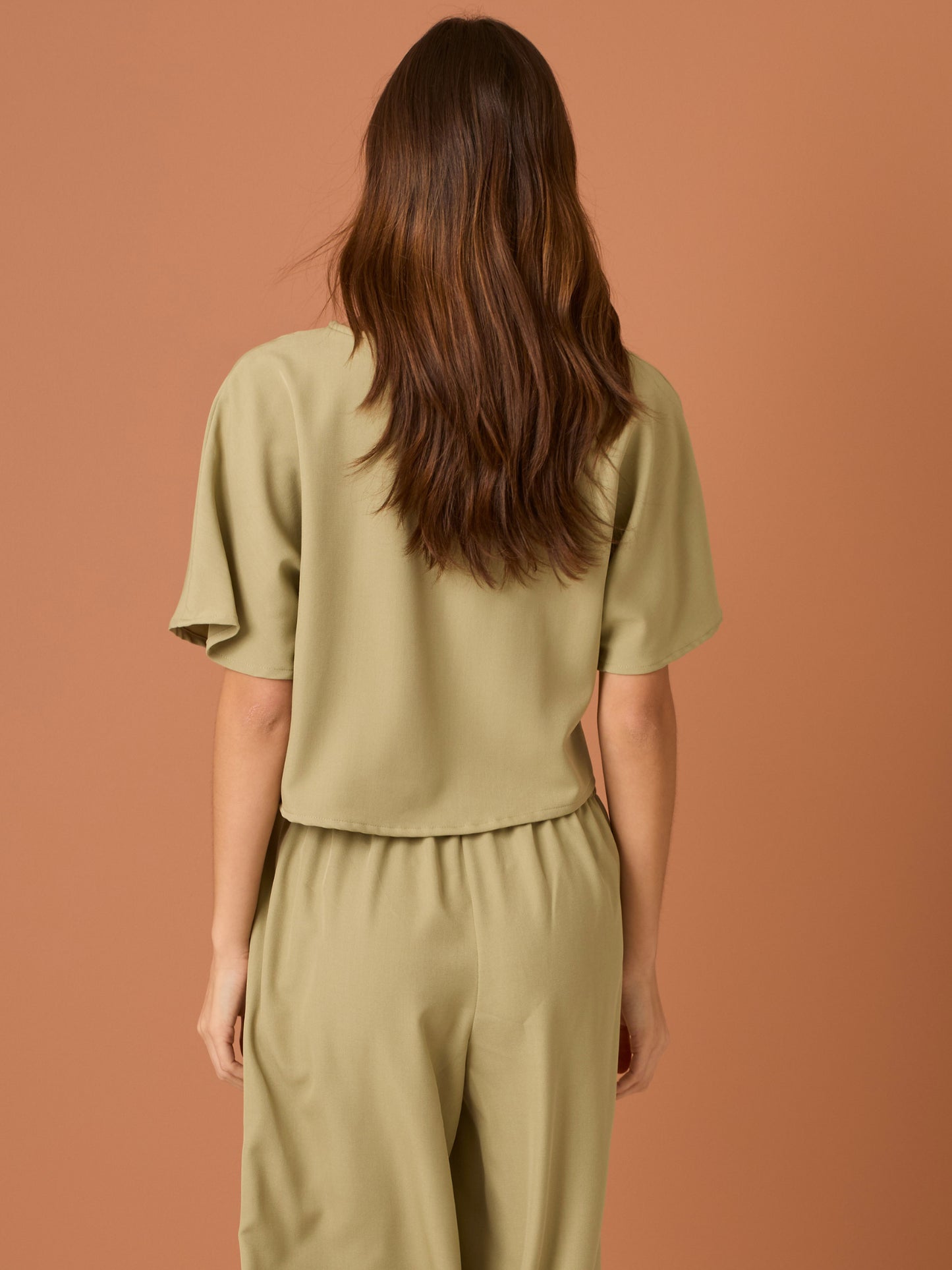 Sencilla y sofisticada, esta blusa de corte recto y fit suelto ofrece comodidad con un acabado limpio. Su diseño de manga corta y cuello cerrado la convierte en una prenda versátil, ideal para looks casuales o combinaciones minimalistas con un aire refinado. Perfecta para el día a día con estilo relajado y moderno.