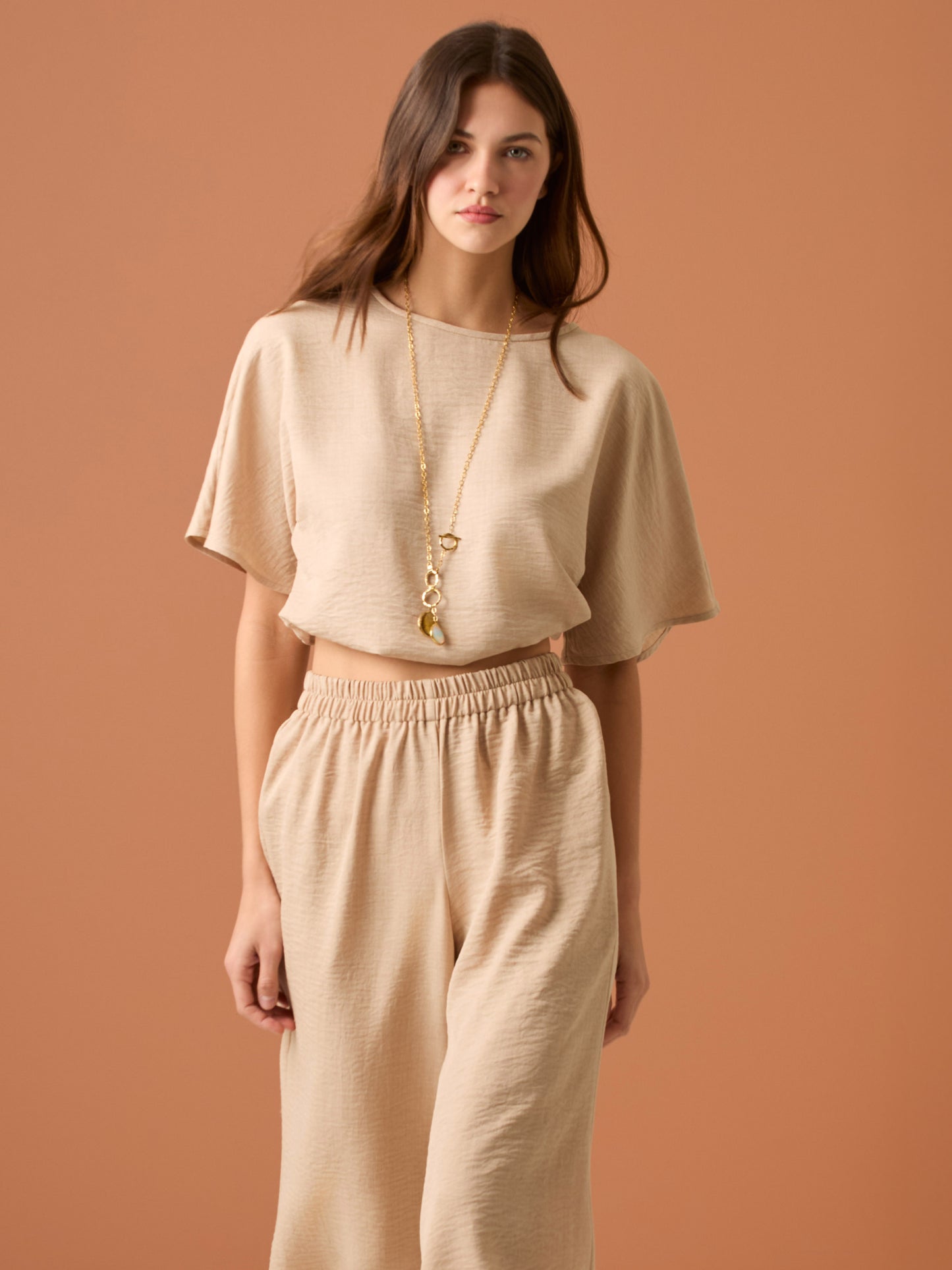 Sencilla y sofisticada, esta blusa de corte recto y fit suelto ofrece comodidad con un acabado limpio. Su diseño de manga corta y cuello cerrado la convierte en una prenda versátil, ideal para looks casuales o combinaciones minimalistas con un aire refinado. Perfecta para el día a día con estilo relajado y moderno.