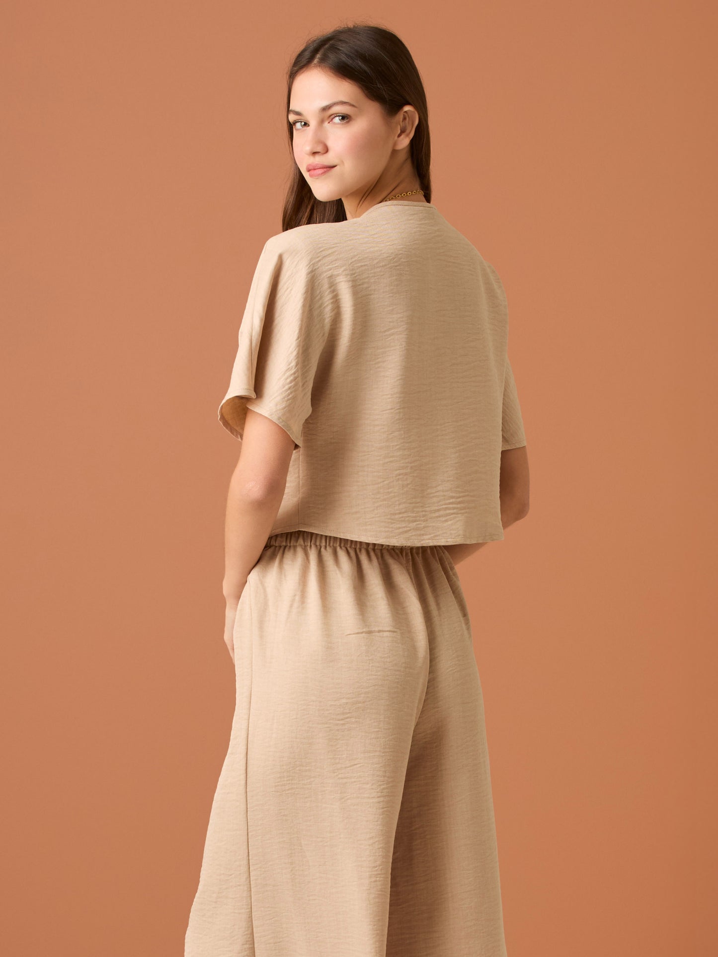 Sencilla y sofisticada, esta blusa de corte recto y fit suelto ofrece comodidad con un acabado limpio. Su diseño de manga corta y cuello cerrado la convierte en una prenda versátil, ideal para looks casuales o combinaciones minimalistas con un aire refinado. Perfecta para el día a día con estilo relajado y moderno.