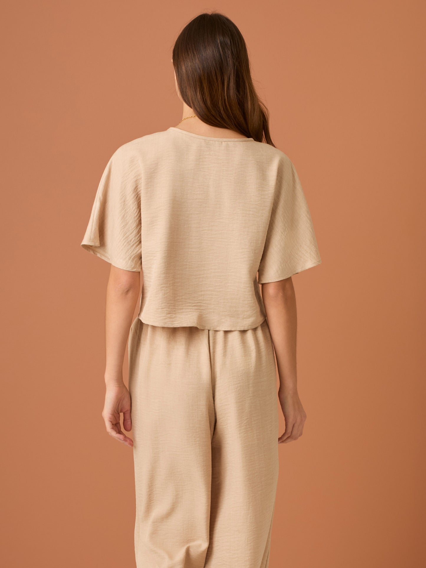 Sencilla y sofisticada, esta blusa de corte recto y fit suelto ofrece comodidad con un acabado limpio. Su diseño de manga corta y cuello cerrado la convierte en una prenda versátil, ideal para looks casuales o combinaciones minimalistas con un aire refinado. Perfecta para el día a día con estilo relajado y moderno.