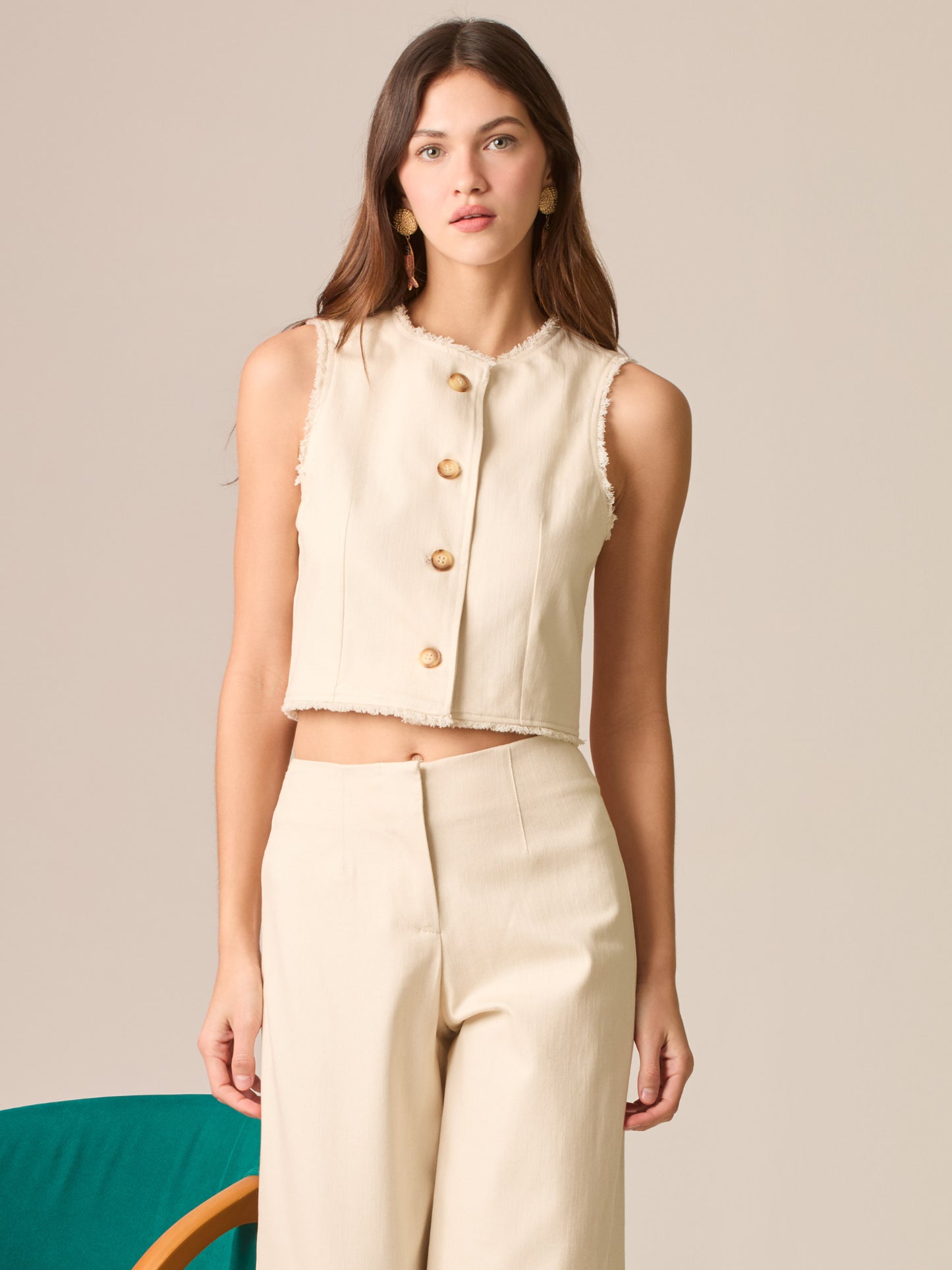 Blusa cropped sin mangas, escote redondo y botonadura frontal; bordes deshilachados y silueta entallada que realza la cintura—ideal para coordinar con tiro alto.
Detalles:
Color: Sand
Material: 98% Algodón 2% Elastomero
Cuidado: Lavar a mano con jabón suave, por separado.No dejar en remojo. Planchar a temperatura alta.