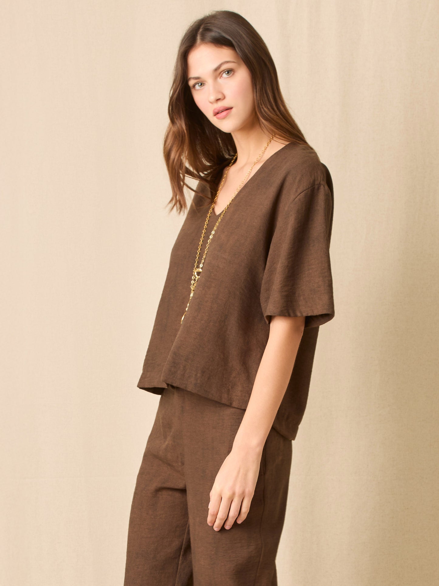 Esta blusa se distingue por su silueta relajada y moderna. Tiene un escote en “V” que estiliza el cuello y mangas amplias de corte medio, lo que le da un aire fresco y cómodo. Su caída recta, ligeramente suelta, aporta un estilo sofisticado y natural, perfecto para un look minimalista pero con presencia
Detalles:
Color: Cafe
Material: 100% Poliéster 