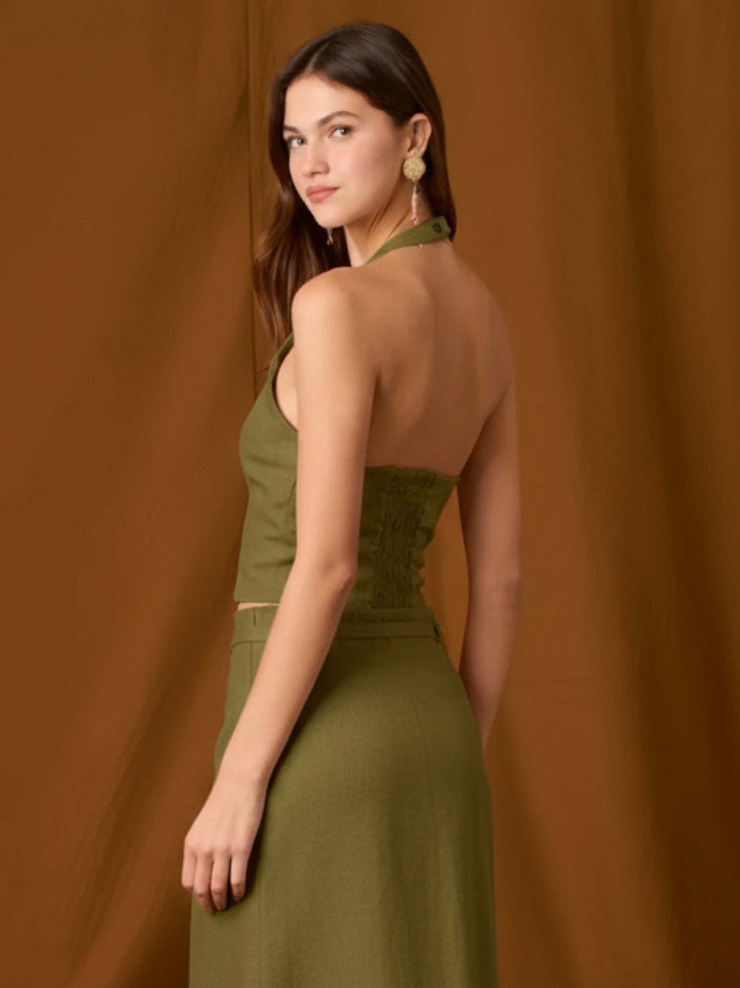 Chaleco-top sin mangas, de silueta entallada y escote en V que resalta el cuello. Lleva botones frontales visibles, pinzas que definen la figura y un pequeño bolsillo en el pecho. Largo a la cintura con bajo levemente curvo: ideal para llevar solo o en capas y completar conjuntos coordinados
Detalles:
Color: Olivo