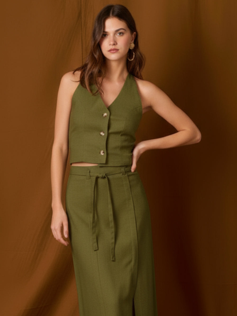 Chaleco-top sin mangas, de silueta entallada y escote en V que resalta el cuello. Lleva botones frontales visibles, pinzas que definen la figura y un pequeño bolsillo en el pecho. Largo a la cintura con bajo levemente curvo: ideal para llevar solo o en capas y completar conjuntos coordinados
Detalles:
Color: Olivo