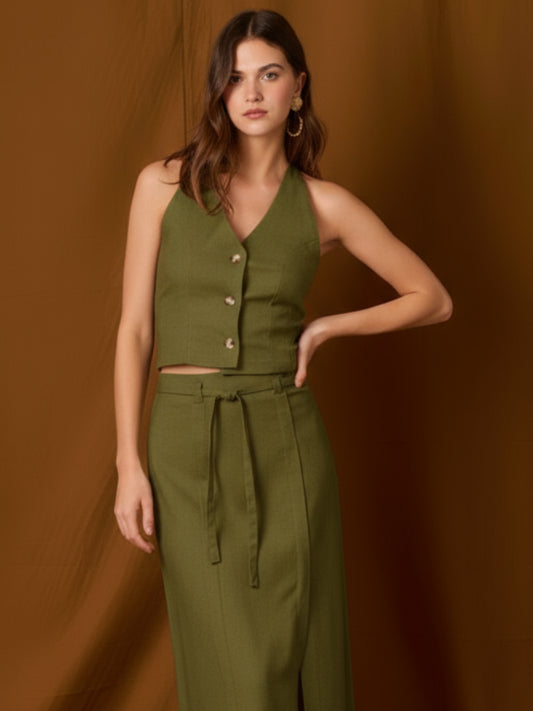 Chaleco-top sin mangas, de silueta entallada y escote en V que resalta el cuello. Lleva botones frontales visibles, pinzas que definen la figura y un pequeño bolsillo en el pecho. Largo a la cintura con bajo levemente curvo: ideal para llevar solo o en capas y completar conjuntos coordinados
Detalles:
Color: Olivo