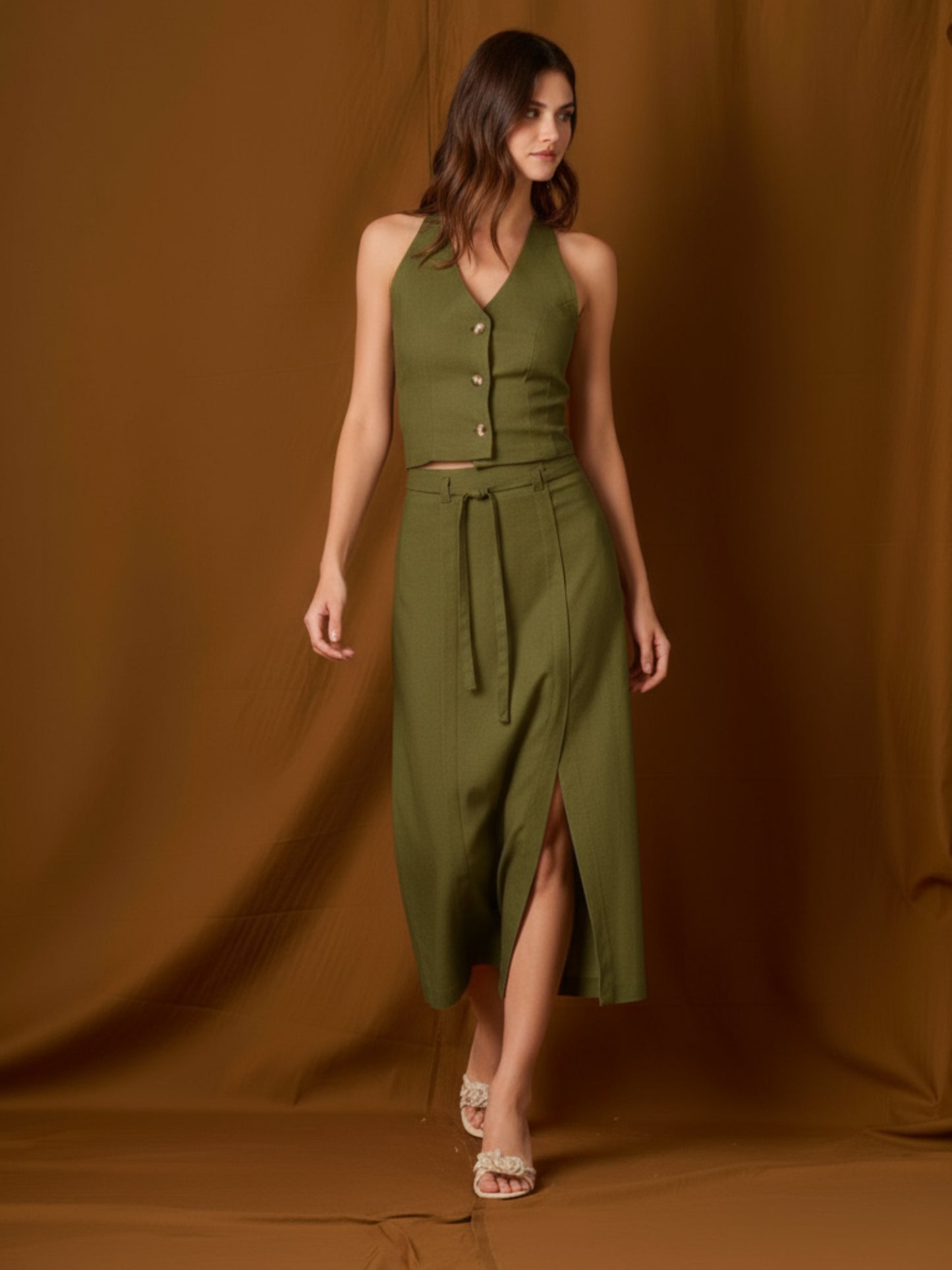 Falda midi de tiro alto con pretina y pasadores, cinturón delgado para ajustar y cruce tipo pareo al frente con abertura lateral que alarga la silueta. Caída recta con leve evasé y largo a media pierna para un movimiento fluido. Versátil y sofisticada para elevar tus looks de día o de noche.