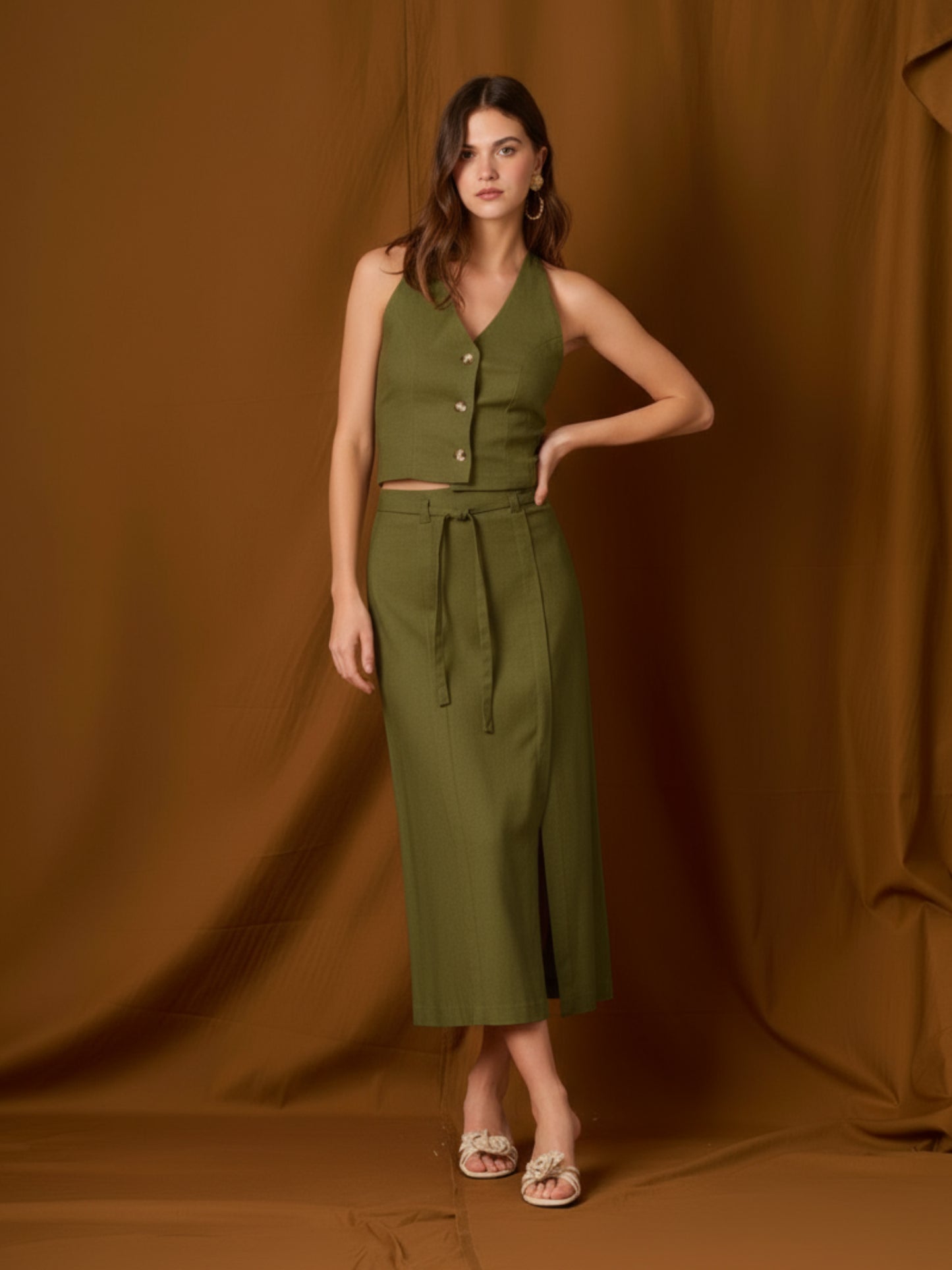 Falda midi de tiro alto con pretina y pasadores, cinturón delgado para ajustar y cruce tipo pareo al frente con abertura lateral que alarga la silueta. Caída recta con leve evasé y largo a media pierna para un movimiento fluido. Versátil y sofisticada para elevar tus looks de día o de noche.