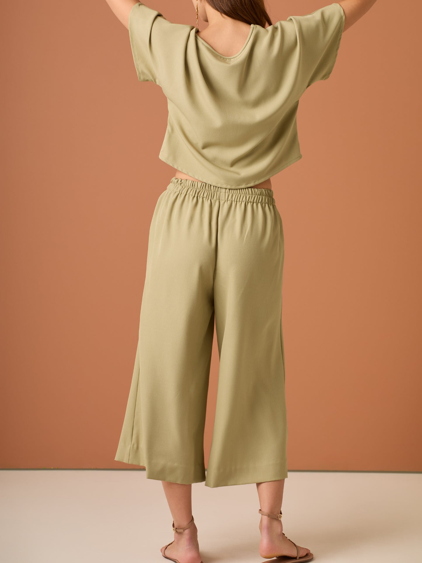 Con una silueta relajada y favorecedora, este pantalón amplio ofrece comodidad sin sacrificar estilo. Su pretina elástica asegura un ajuste cómodo y práctico, mientras que el largo al tobillo y la caída ligera lo convierten en una opción ideal para looks casuales sofisticados o días de movimiento con un aire minimalista y pulido.