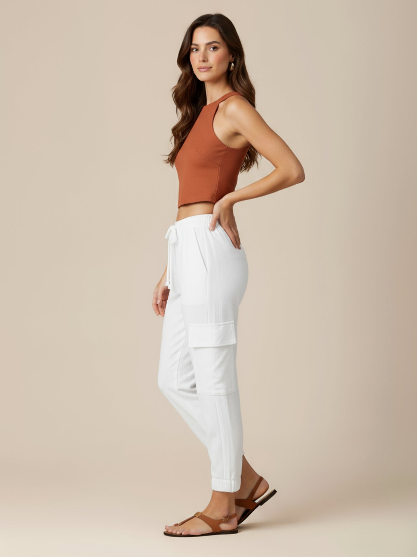 Este pantalón combina comodidad y estilo en un diseño moderno. Presenta pretina elástica con cordón ajustable que se adapta perfectamente a la cintura, bolsillos laterales tipo cargo que aportan un aire práctico y urbano, y terminaciones con elástico en los tobillos que estilizan la silueta. Su corte relajado lo convierte en una prenda versátil y actual, ideal para un look casual y sofisticado al mismo tiempo. Perfecto para quienes buscan frescura y dinamismo sin perder elegancia.