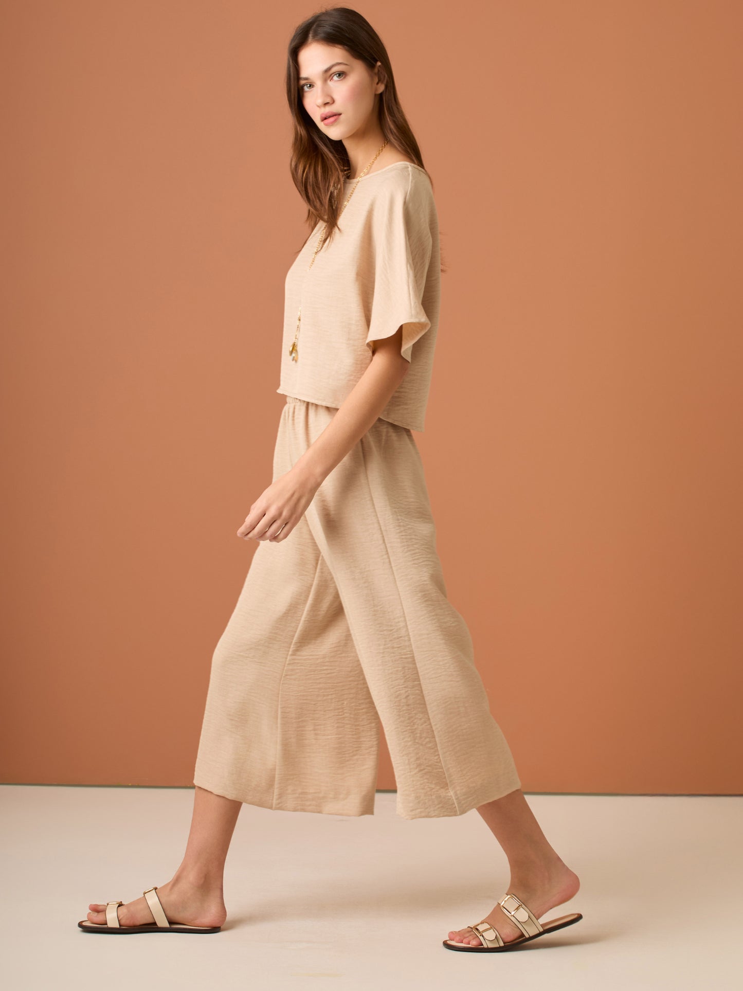 Con una silueta relajada y favorecedora, este pantalón amplio ofrece comodidad sin sacrificar estilo. Su pretina elástica asegura un ajuste cómodo y práctico, mientras que el largo al tobillo y la caída ligera lo convierten en una opción ideal para looks casuales sofisticados o días de movimiento con un aire minimalista y pulido.