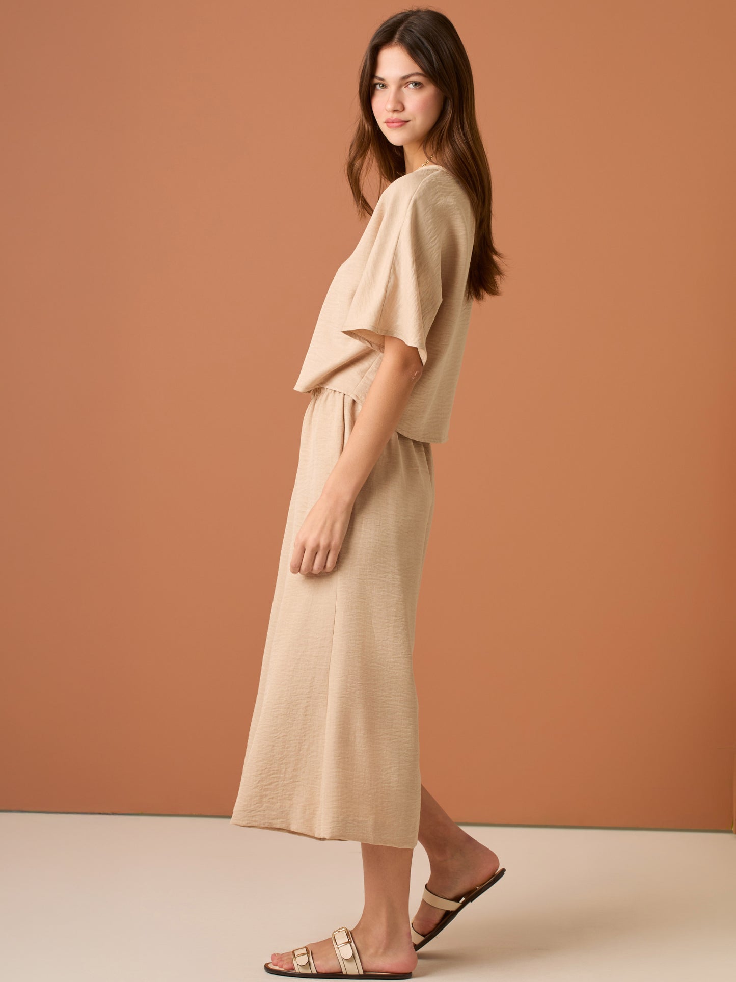 Con una silueta relajada y favorecedora, este pantalón amplio ofrece comodidad sin sacrificar estilo. Su pretina elástica asegura un ajuste cómodo y práctico, mientras que el largo al tobillo y la caída ligera lo convierten en una opción ideal para looks casuales sofisticados o días de movimiento con un aire minimalista y pulido.