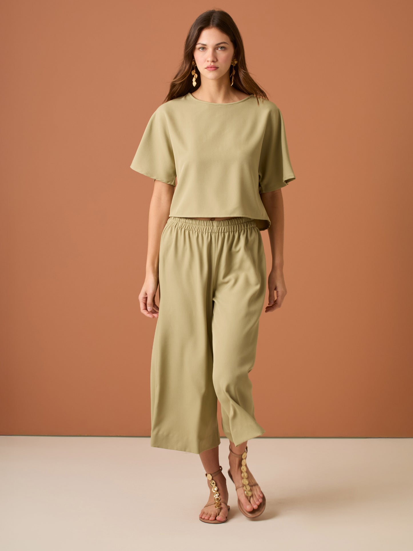 Con una silueta relajada y favorecedora, este pantalón amplio ofrece comodidad sin sacrificar estilo. Su pretina elástica asegura un ajuste cómodo y práctico, mientras que el largo al tobillo y la caída ligera lo convierten en una opción ideal para looks casuales sofisticados o días de movimiento con un aire minimalista y pulido.