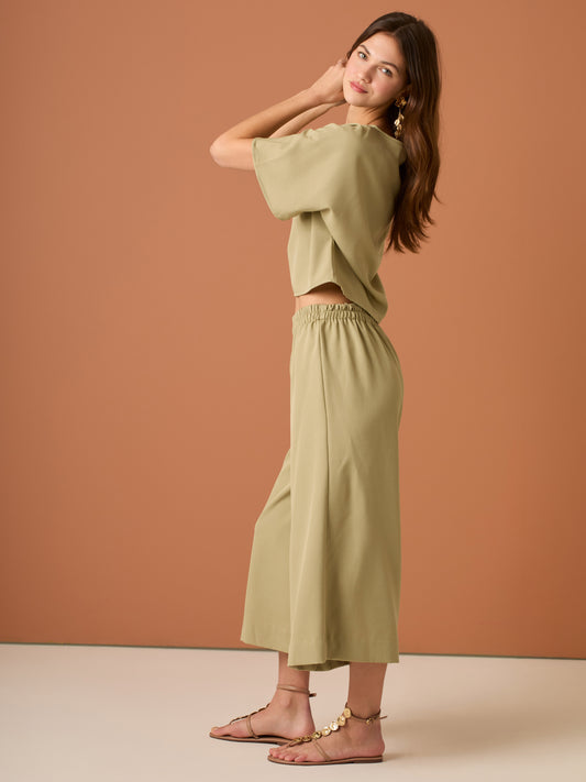 Con una silueta relajada y favorecedora, este pantalón amplio ofrece comodidad sin sacrificar estilo. Su pretina elástica asegura un ajuste cómodo y práctico, mientras que el largo al tobillo y la caída ligera lo convierten en una opción ideal para looks casuales sofisticados o días de movimiento con un aire minimalista y pulido.