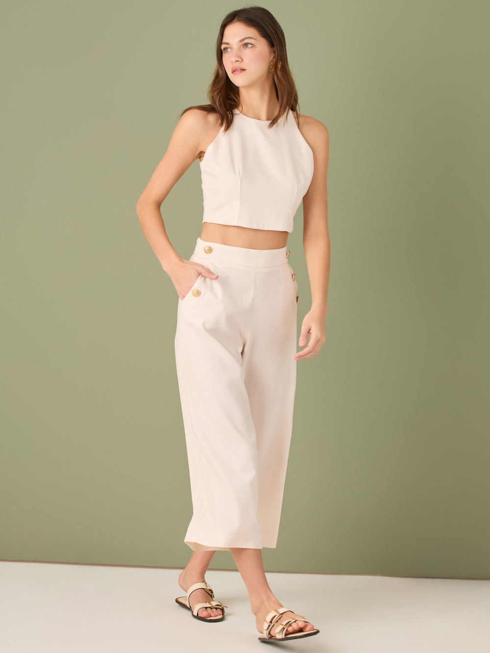 Pantalón culotte de tiro alto y pierna ancha; largo cropped que alarga la silueta, cintura entallada y botones laterales estilo marinero—versátil y elegante para looks casual-chic
Detalles:
Color: Ivory
Material: 100% lino. Forro 100% Rayón