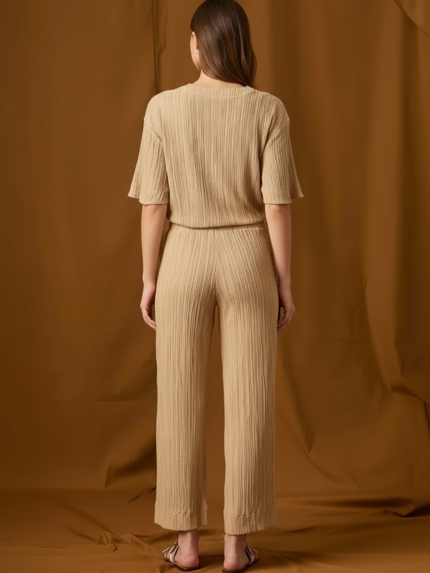 Pantalón fluido de silueta relajada y tiro medio, con pretina elástica y jareta ajustable. Pernera recta-amplia hasta el tobillo, bolsillos laterales y textura arrugada que aporta movimiento. Cómodo y versátil para el día a día o viajes; combínalo con tops mínima o la blusa a juego.