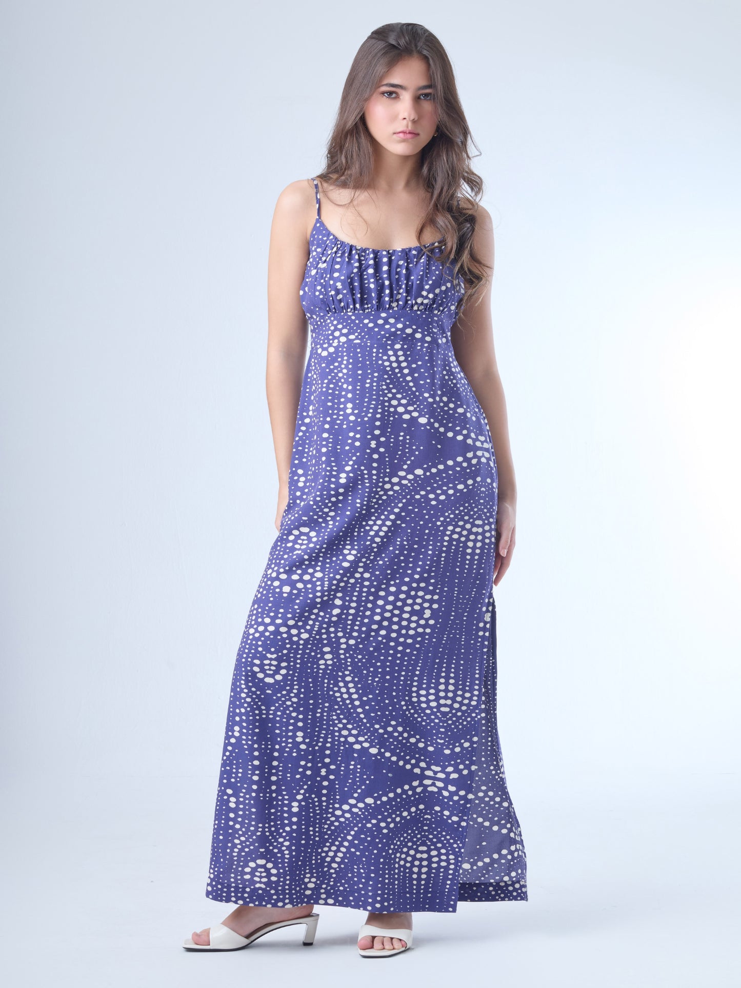 Fluido y femenino, este vestido largo destaca por su escote sutilmente fruncido y silueta que acompaña delicadamente la figura. Los tirantes delgados y el diseño liviano lo convierten en una opción perfecta para climas cálidos, cenas al aire libre o eventos con un aire relajado y chic. Una pieza que equilibra comodidad con sofisticación contemporánea.