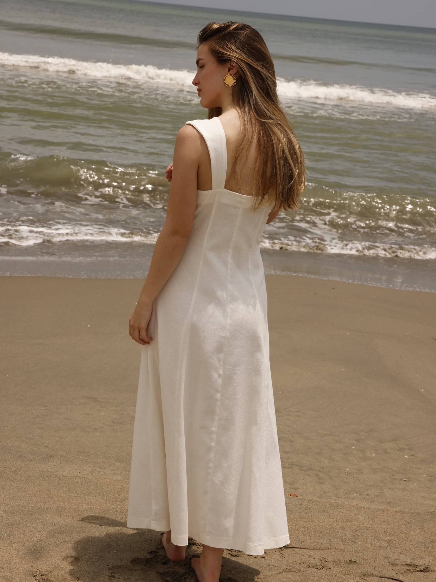 Este vestido largo tiene un diseño fresco y elegante, ideal para días cálidos. Cuenta con un escote cuadrado amplio que resalta los hombros y el cuello, y tirantes anchos que ofrecen soporte y estructura. Su silueta es entallada en la parte superior y se va abriendo hacia la falda, creando un efecto fluido y femenino.
Detalles:
Color: Blanco
Material: 69 % Rayon 29% Lino 2% Elastomero