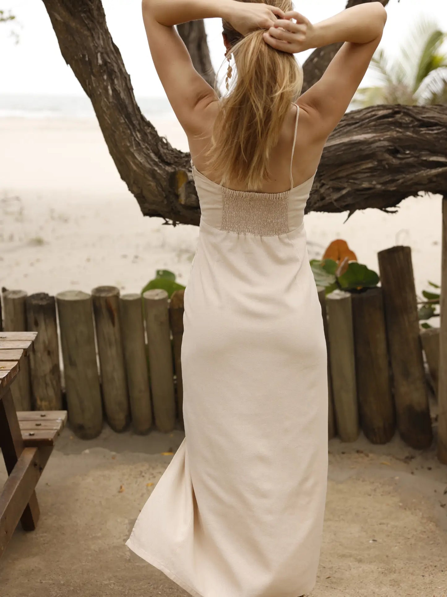 vVestido largo de tirantes delgados con escote halter. Tiene un detalle fruncido en el busto con abertura frontal y un pequeño corte debajo del pecho. La falda incluye una abertura frontal que aporta movimiento y frescura al diseño. Silueta ajustada al cuerpo con caída fluida. Ideal para un look de playa o verano.