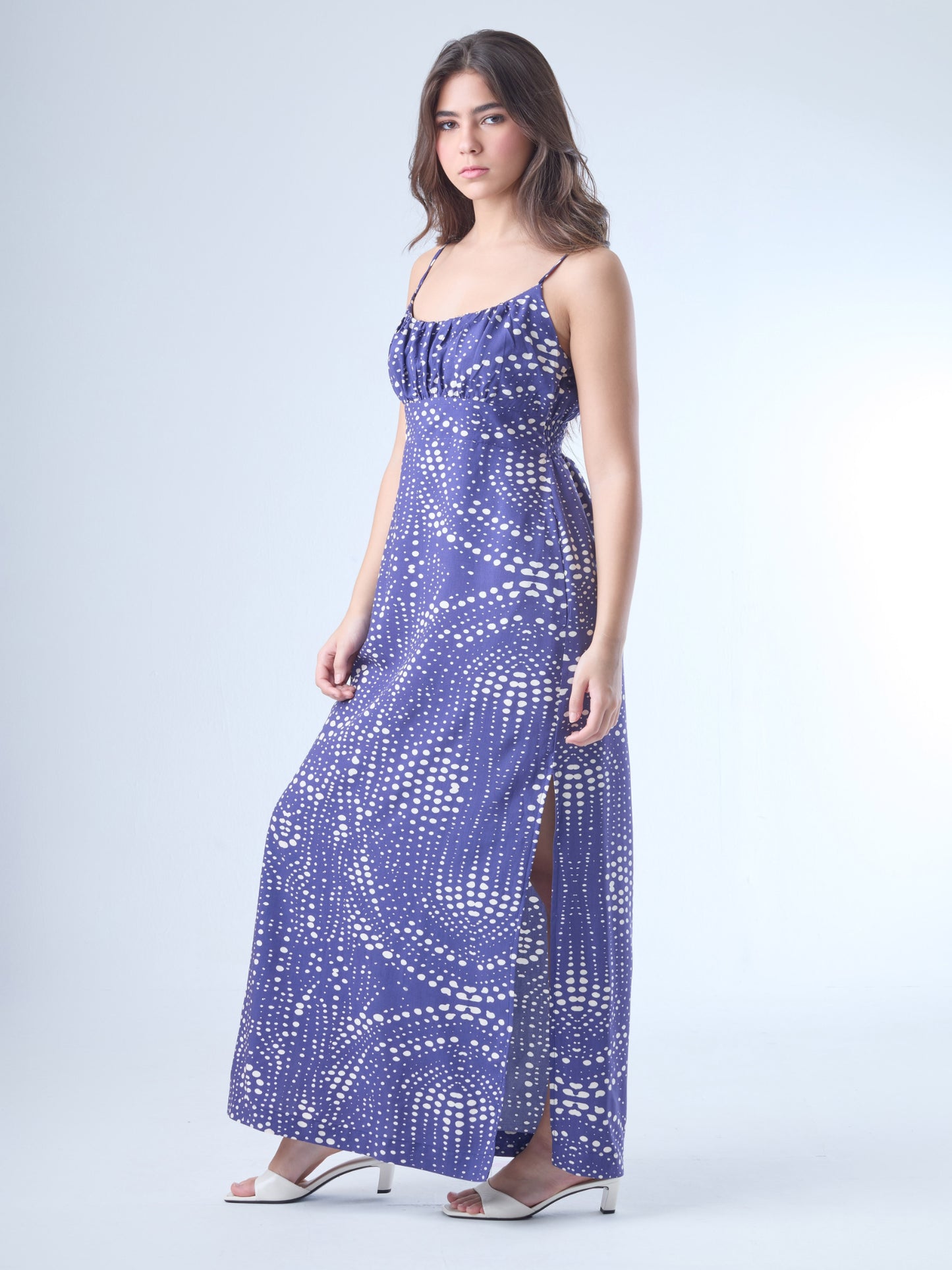 Fluido y femenino, este vestido largo destaca por su escote sutilmente fruncido y silueta que acompaña delicadamente la figura. Los tirantes delgados y el diseño liviano lo convierten en una opción perfecta para climas cálidos, cenas al aire libre o eventos con un aire relajado y chic. Una pieza que equilibra comodidad con sofisticación contemporánea.