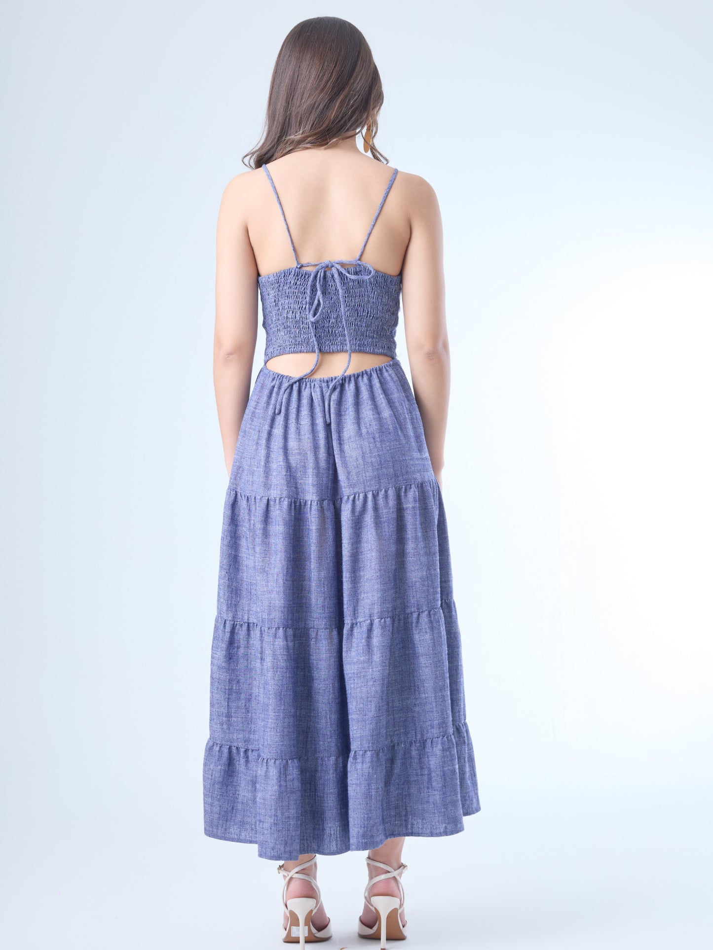 Vestido largo con escote en V profundo y tirantes finos. El cuerpo tiene un diseño cruzado que acentúa el busto y estiliza la figura. La falda está compuesta por paneles amplios con sutiles volantes, que aportan fluidez y un aire romántico. Ideal para un look femenino y relajado.