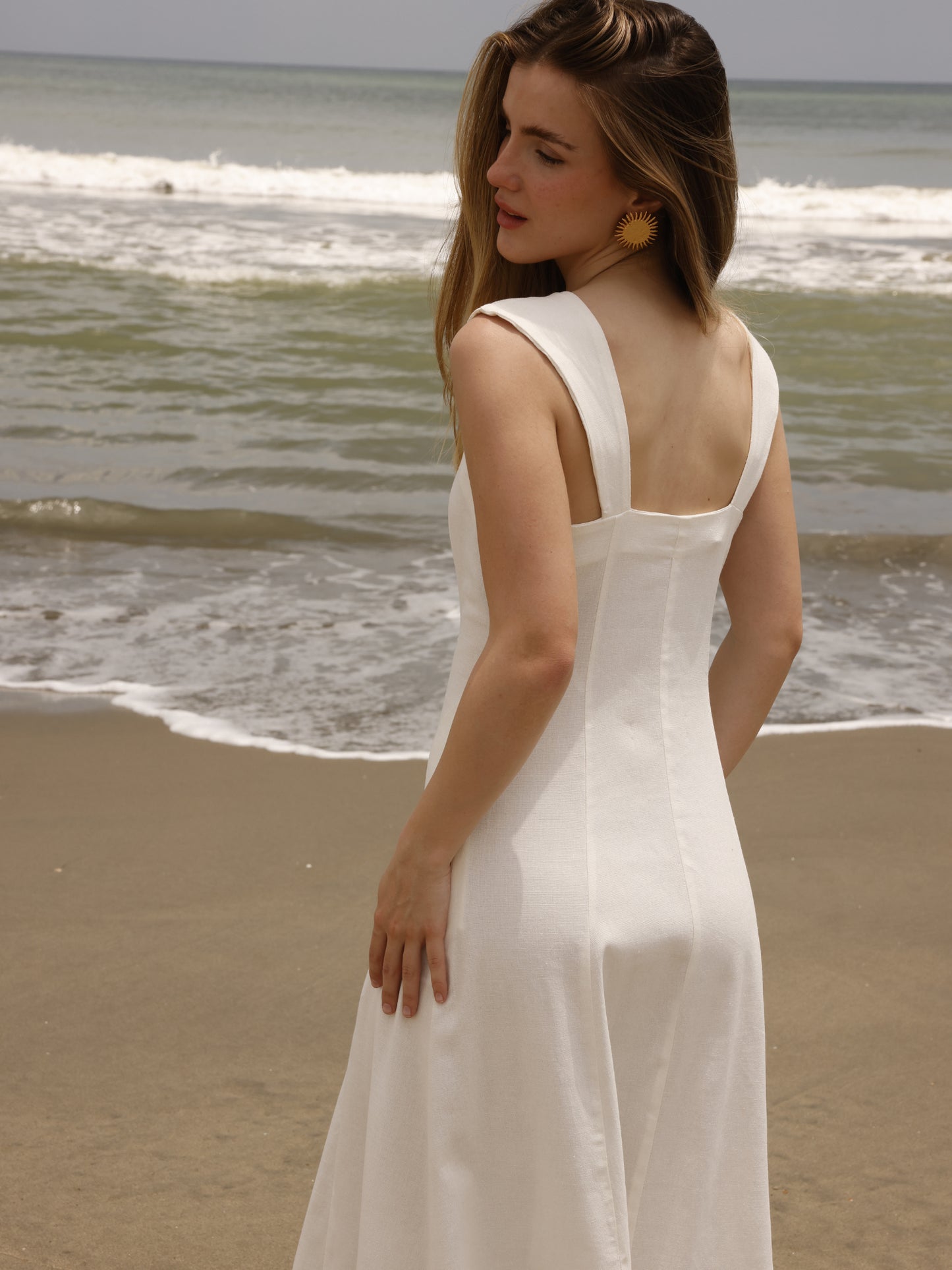 Este vestido largo tiene un diseño fresco y elegante, ideal para días cálidos. Cuenta con un escote cuadrado amplio que resalta los hombros y el cuello, y tirantes anchos que ofrecen soporte y estructura. Su silueta es entallada en la parte superior y se va abriendo hacia la falda, creando un efecto fluido y femenino.
Detalles:
Color: Blanco
Material: 69 % Rayon 29% Lino 2% Elastomero