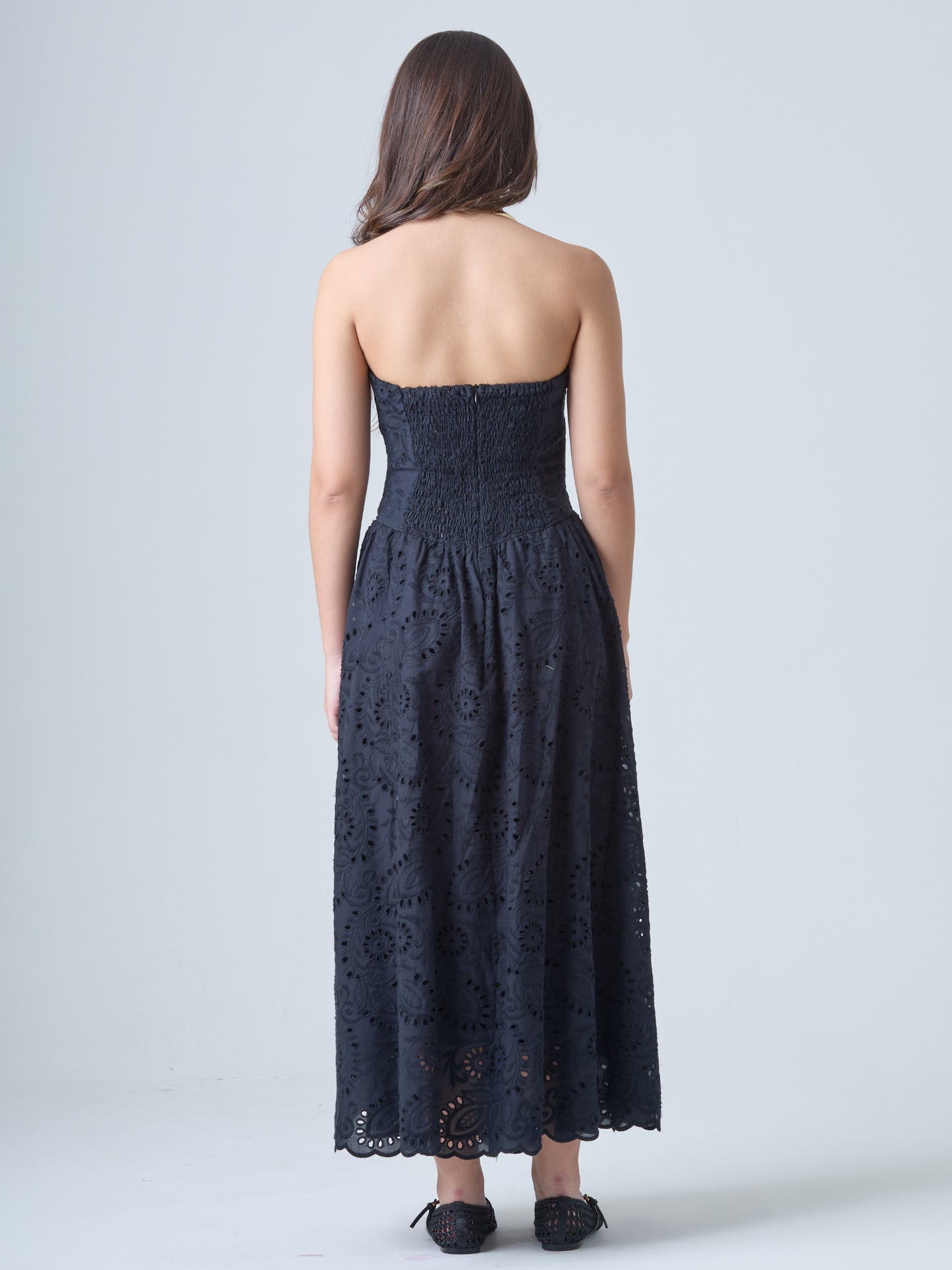 Este elegante vestido strapless, ideal para resaltar los hombros y el cuello con un estilo sofisticado y femenino. Está confeccionado en una telacon bordado inglés, que combina patrones florales y geométricos calados, aportando textura y un aire romántico.