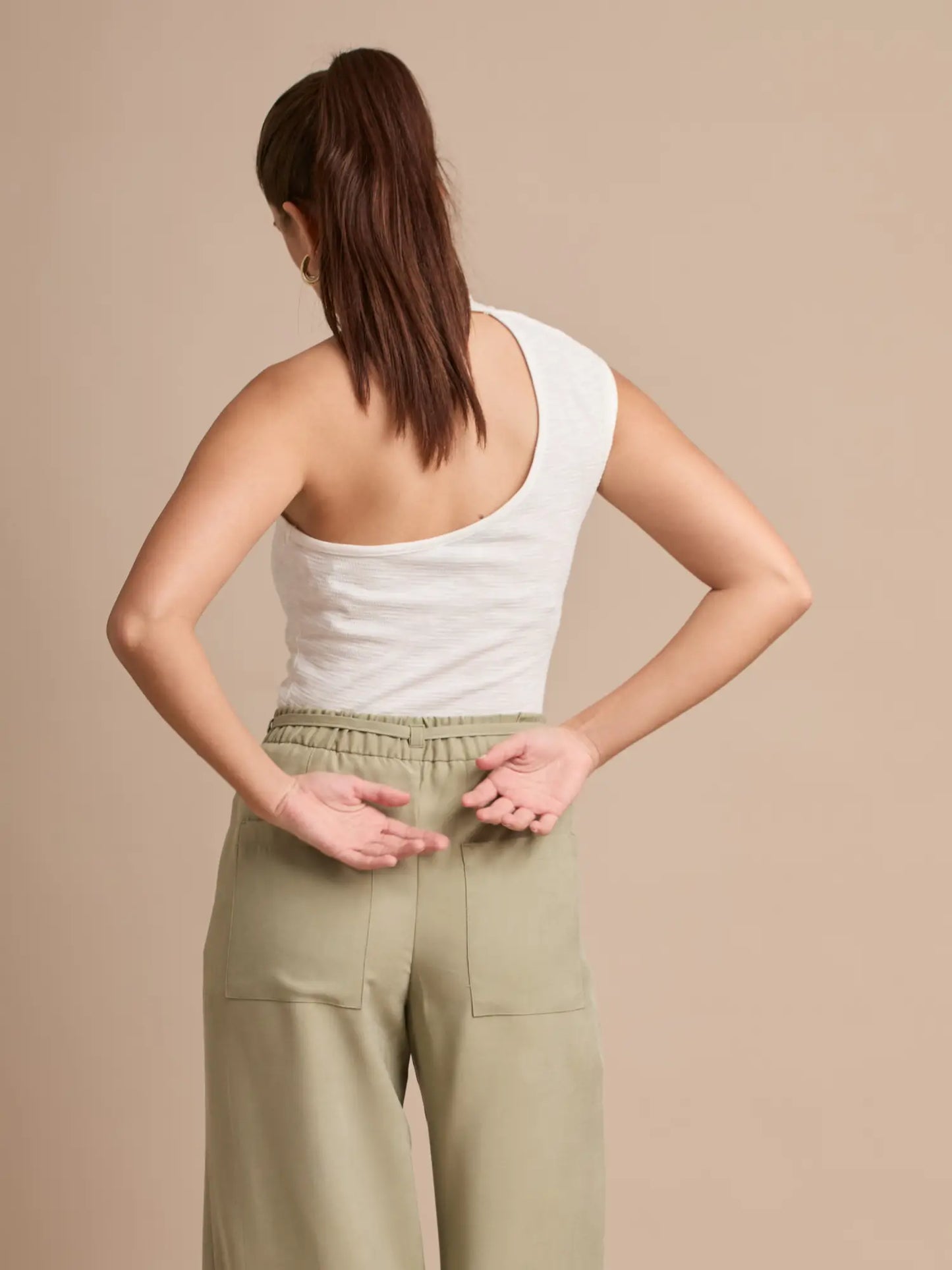 Diseño fresco y contemporáneo en una blusa halter que destaca por su corte asimétrico y detalles metálicos. Ideal para crear outfits minimalistas con un toque chic.