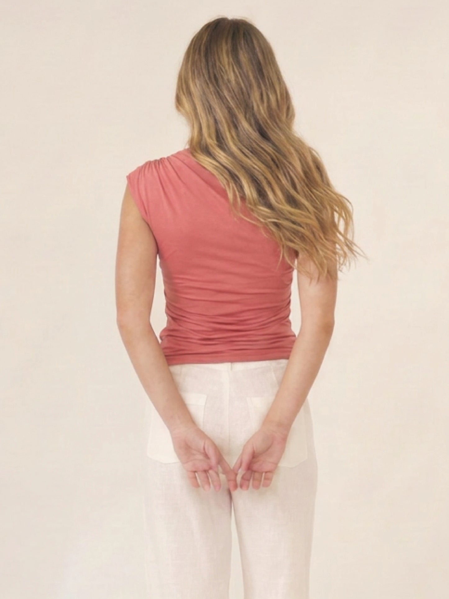Blusa Catania coral con escote diagonal, textura suave y fit al cuerpo