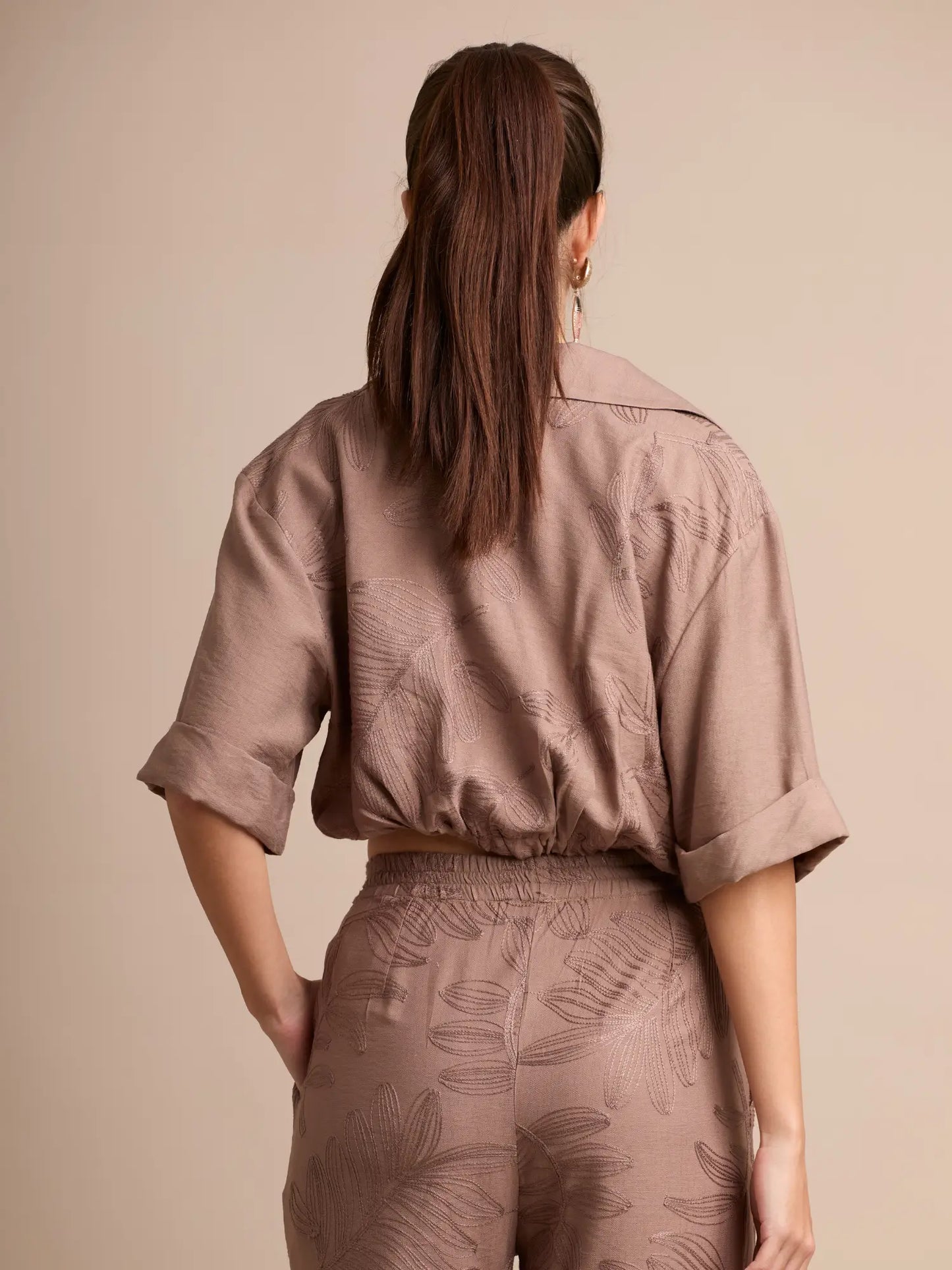 La blusa Seoul Café destaca por su corte ligeramente cropped y su textura floral en relieve. Un diseño versátil que añade estilo sin esfuerzo a cualquier look diario.