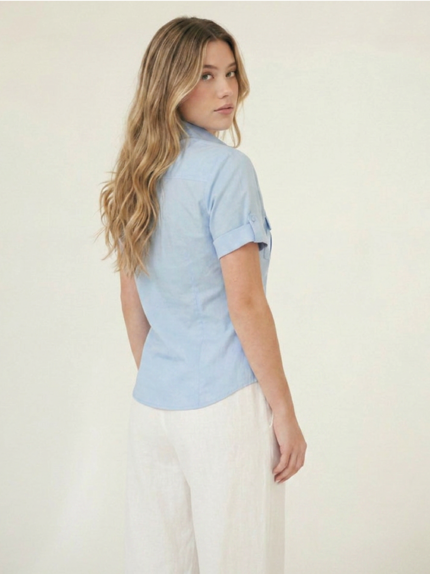 Blusa femenina azul con cuello clásico, bolsillos frontales y manga corta