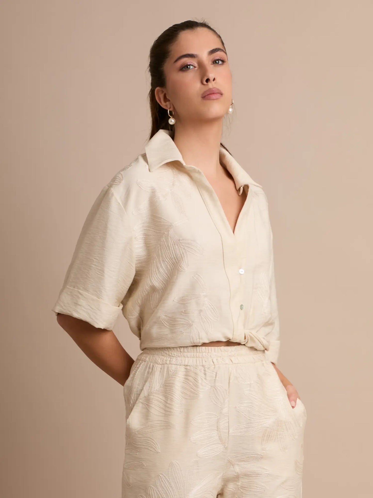 La blusa Seoul Crema destaca por su textura floral en relieve y su cuello abierto que aporta un toque elegante y relajado. Ideal para looks casual-chic y combinaciones monocromáticas.