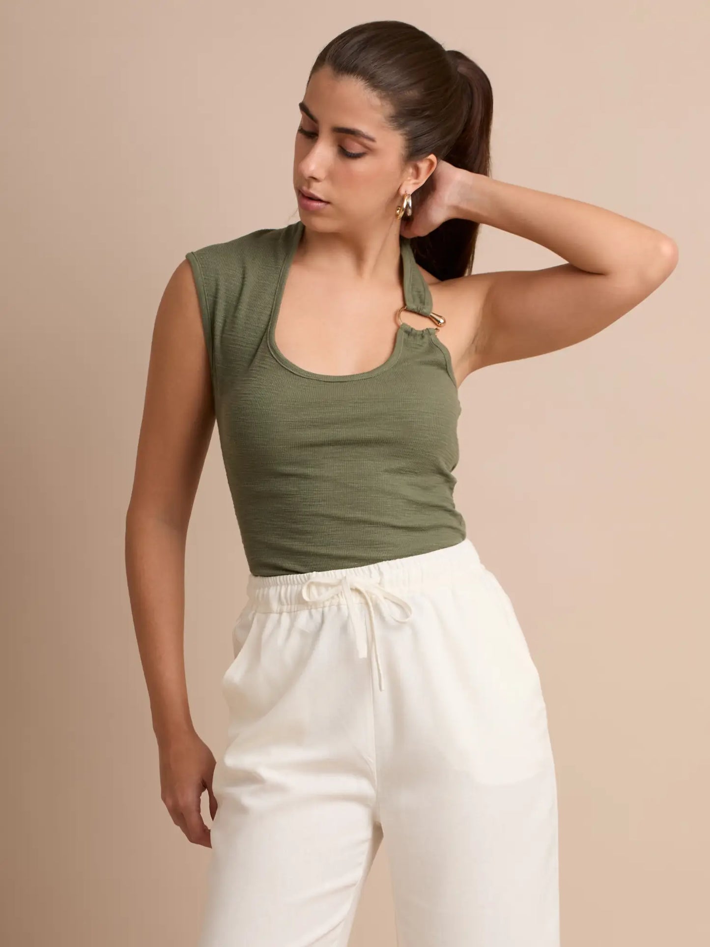 Su diseño asimétrico y la presencia del aro metálico en el escote convierten esta blusa en una pieza especial. Ideal para quienes buscan prendas cómodas pero con carácter y un toque elegante.