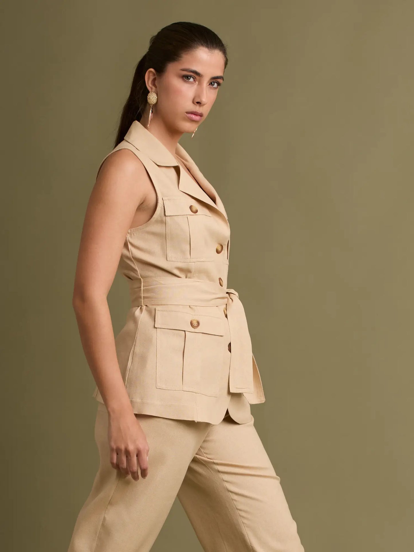 Este chaleco beige sastrero incluye botones decorativos, bolsillos amplios y un cinturón que estiliza la silueta, ideal para crear looks elegantes y casuales