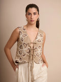 Este chaleco beige con flores bordadas aporta estilo y delicadeza gracias a sus lazos delanteros y su diseño fresco. Una prenda imprescindible para un look chic de día.
