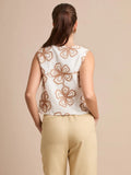 Este chaleco femenino combina un fondo blanco con bordado detallado en tonos tierra y lazos ajustables al frente. Una pieza versátil para un look natural y elegante.