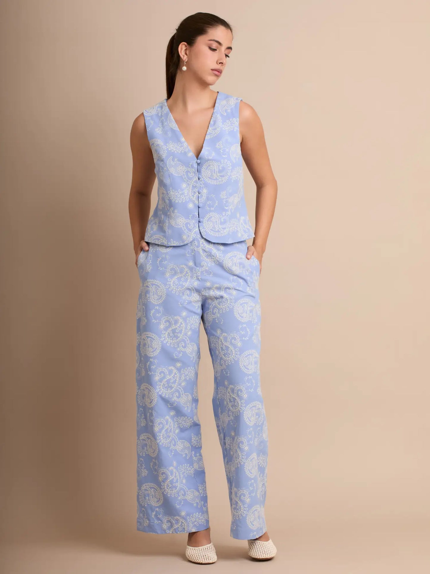 Este set azul combina un chaleco sin mangas con escote en V y un pantalón recto de talle medio. Su estampado elegante aporta frescura y estilo, ideal para looks de primavera y verano. Perfecto para un outfit sofisticado y cómodo.