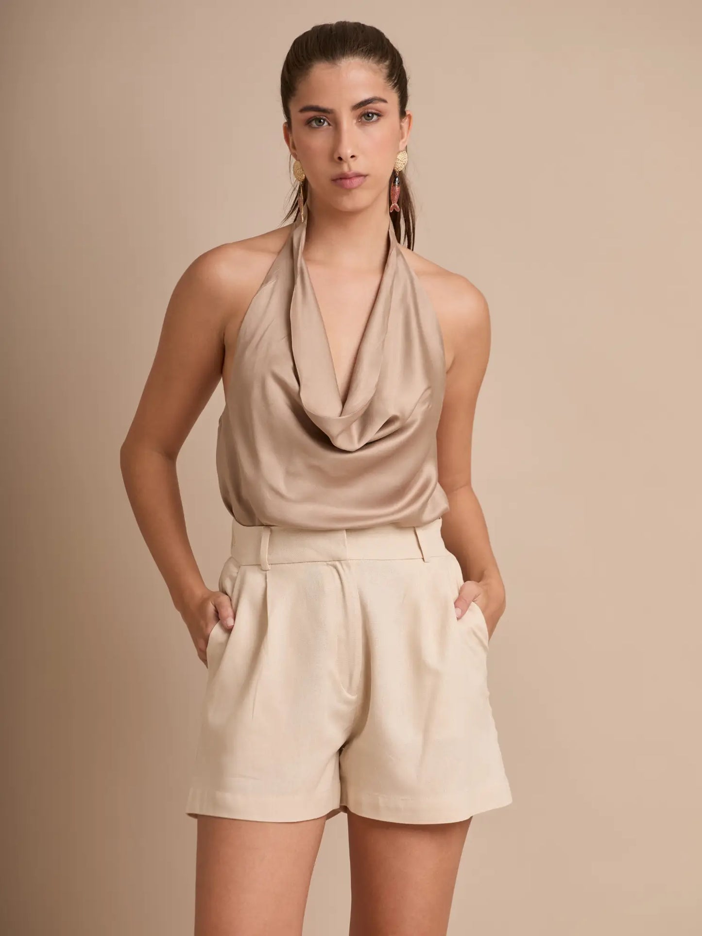 El short beige minimalista cuenta con bolsillos funcionales y una basta recta que estiliza las piernas. Su diseño sencillo y sofisticado es perfecto para outfits neutrales y atemporales.