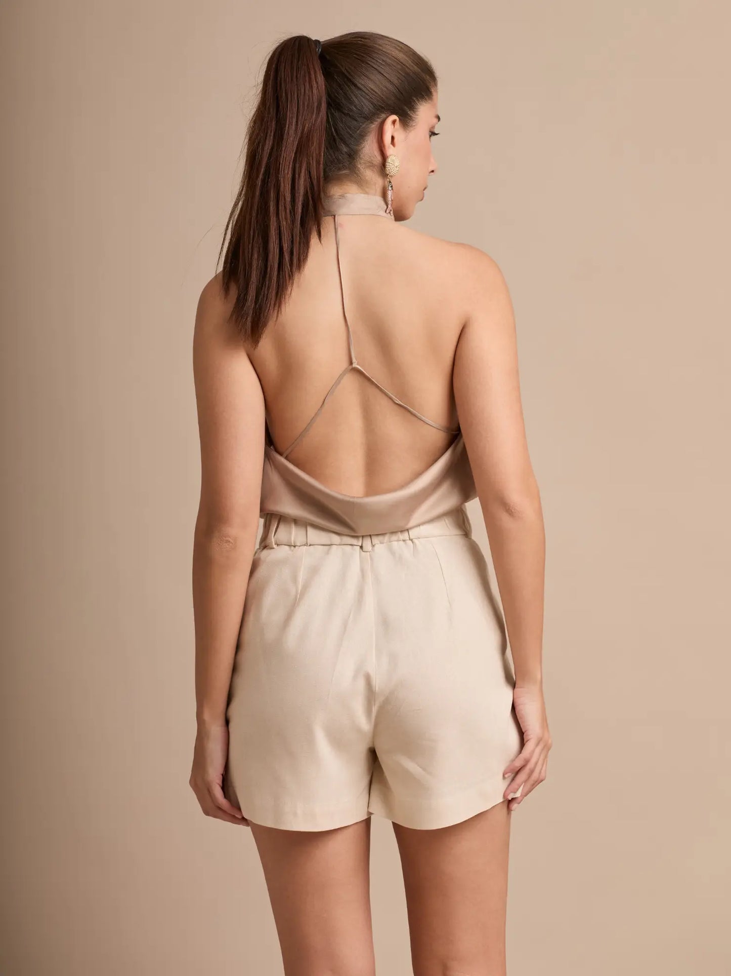 Este short beige de tiro alto-medio tiene una silueta relajada que permite libertad de movimiento. Su largo medio lo convierte en una opción elegante y cómoda para el día a día.